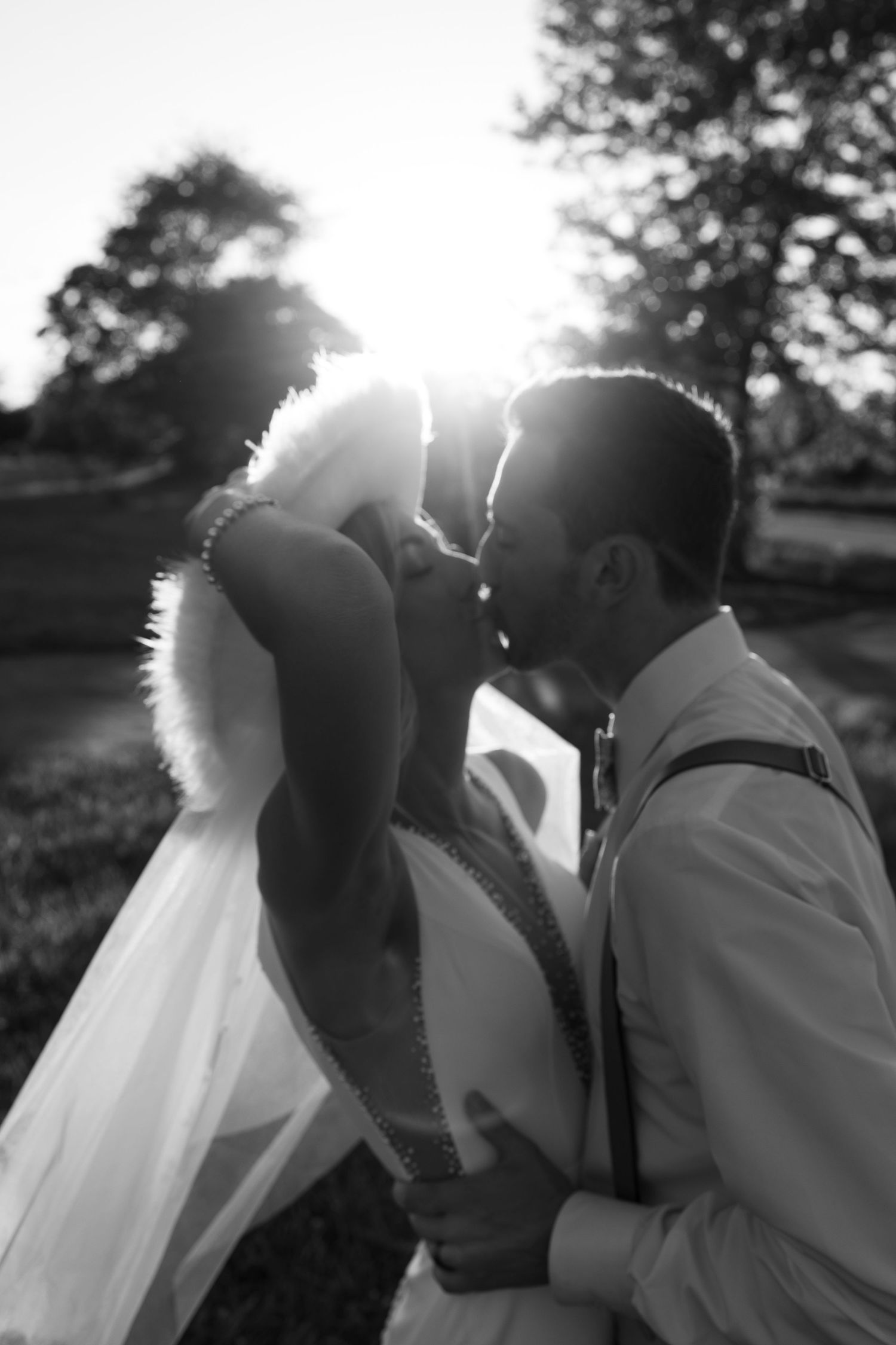 Silhouetted wedding couple sharing intimate moments at sunset.