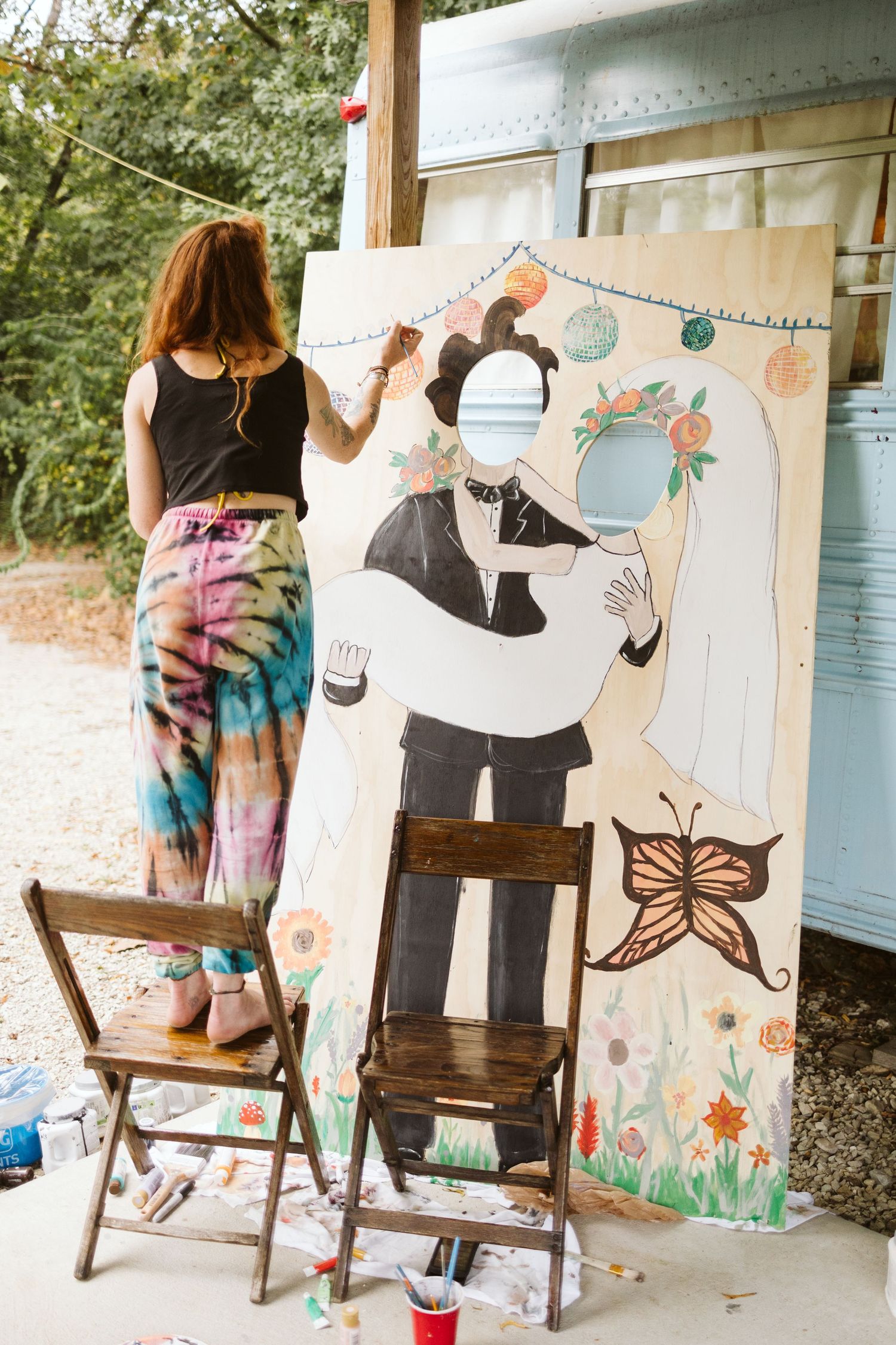A whimsical photo booth setup with painted backdrops and decorative banners at an outdoor event.