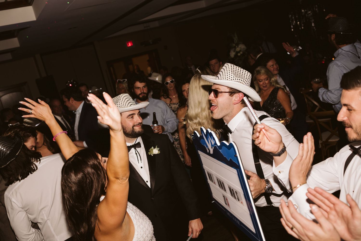 Wedding guests dance and celebrate during a lively reception party.