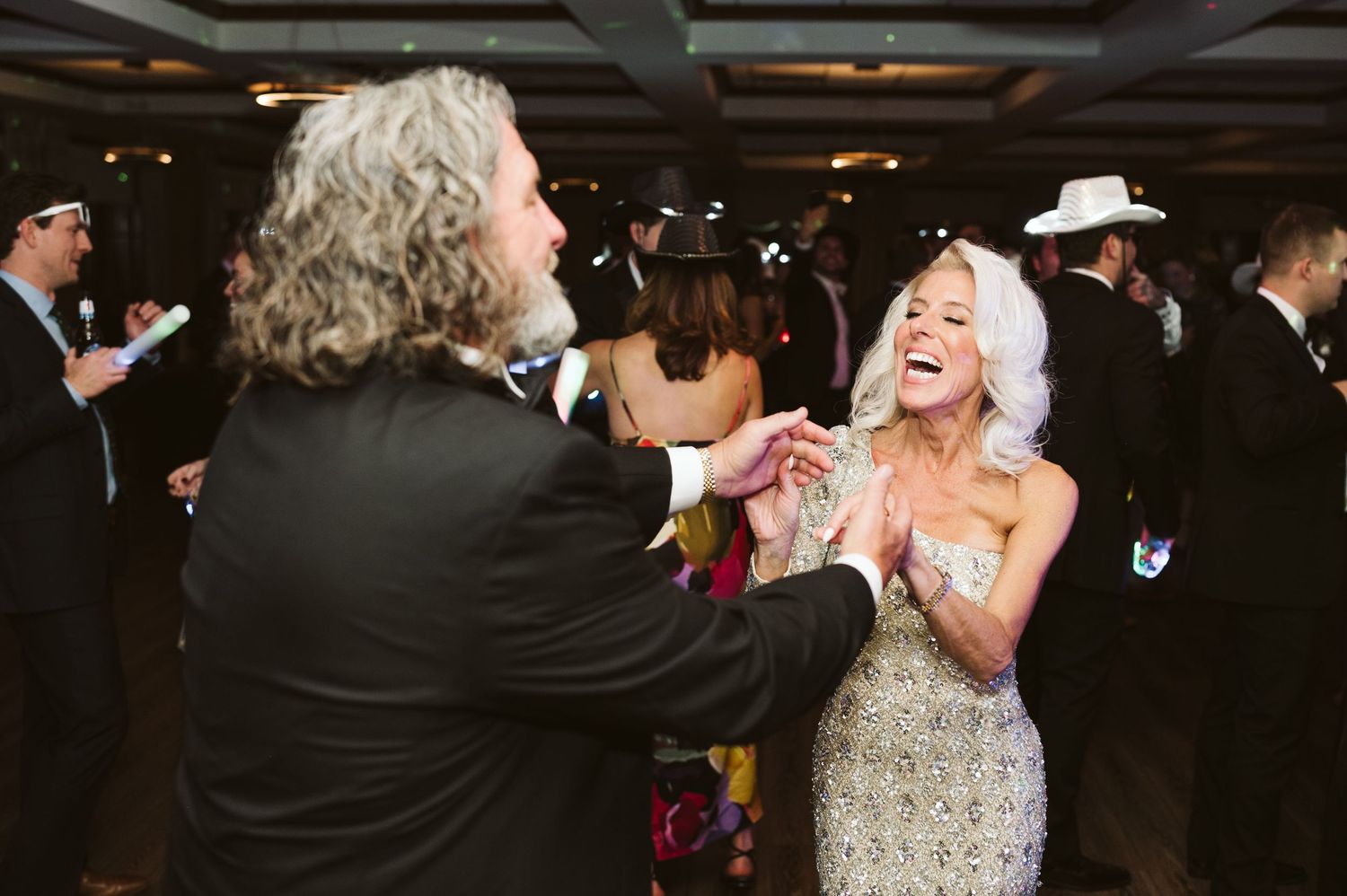 Guests dancing and celebrating at an elegant indoor wedding reception.