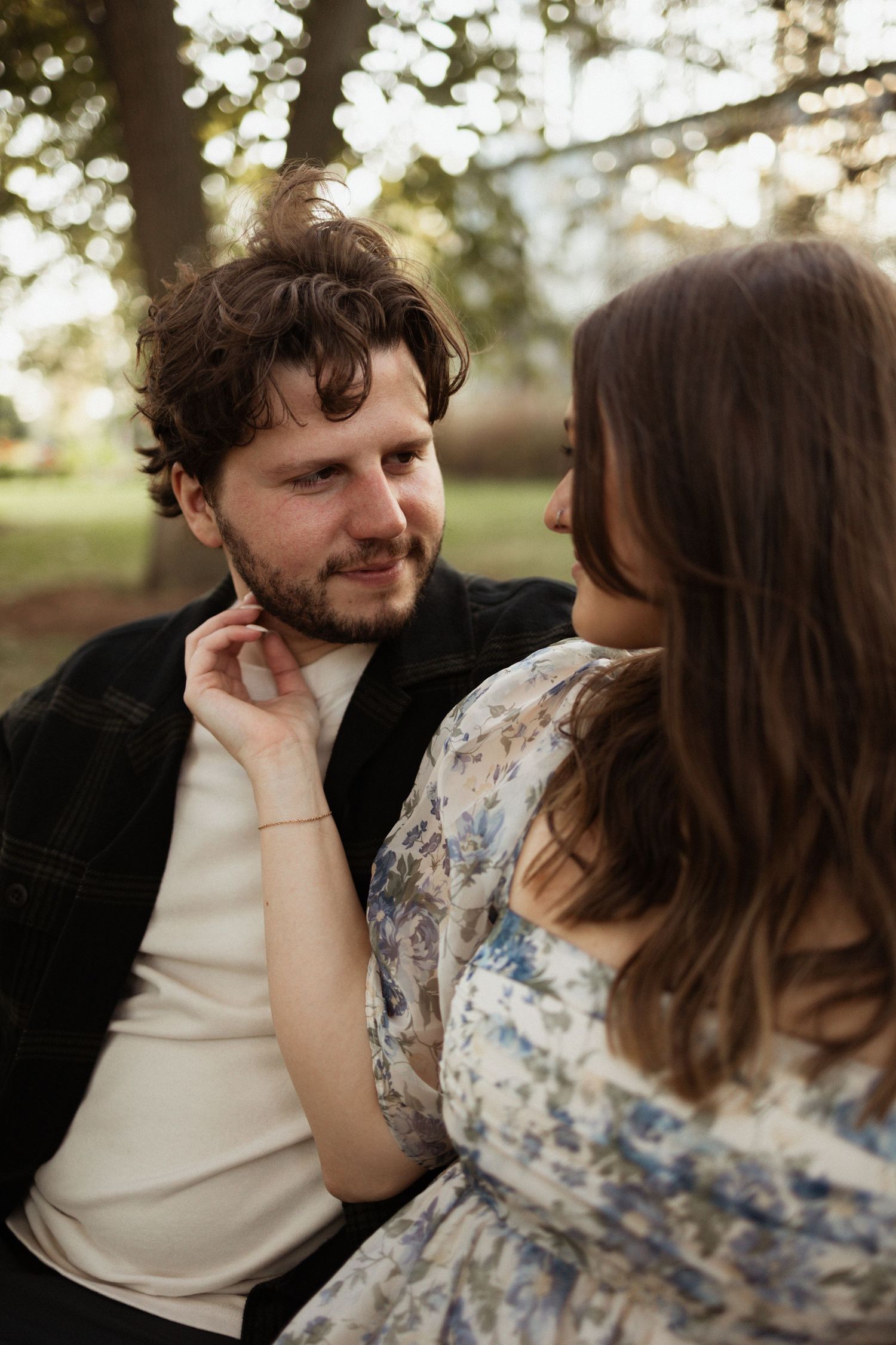 A tender moment shared between two people in natural outdoor lighting.