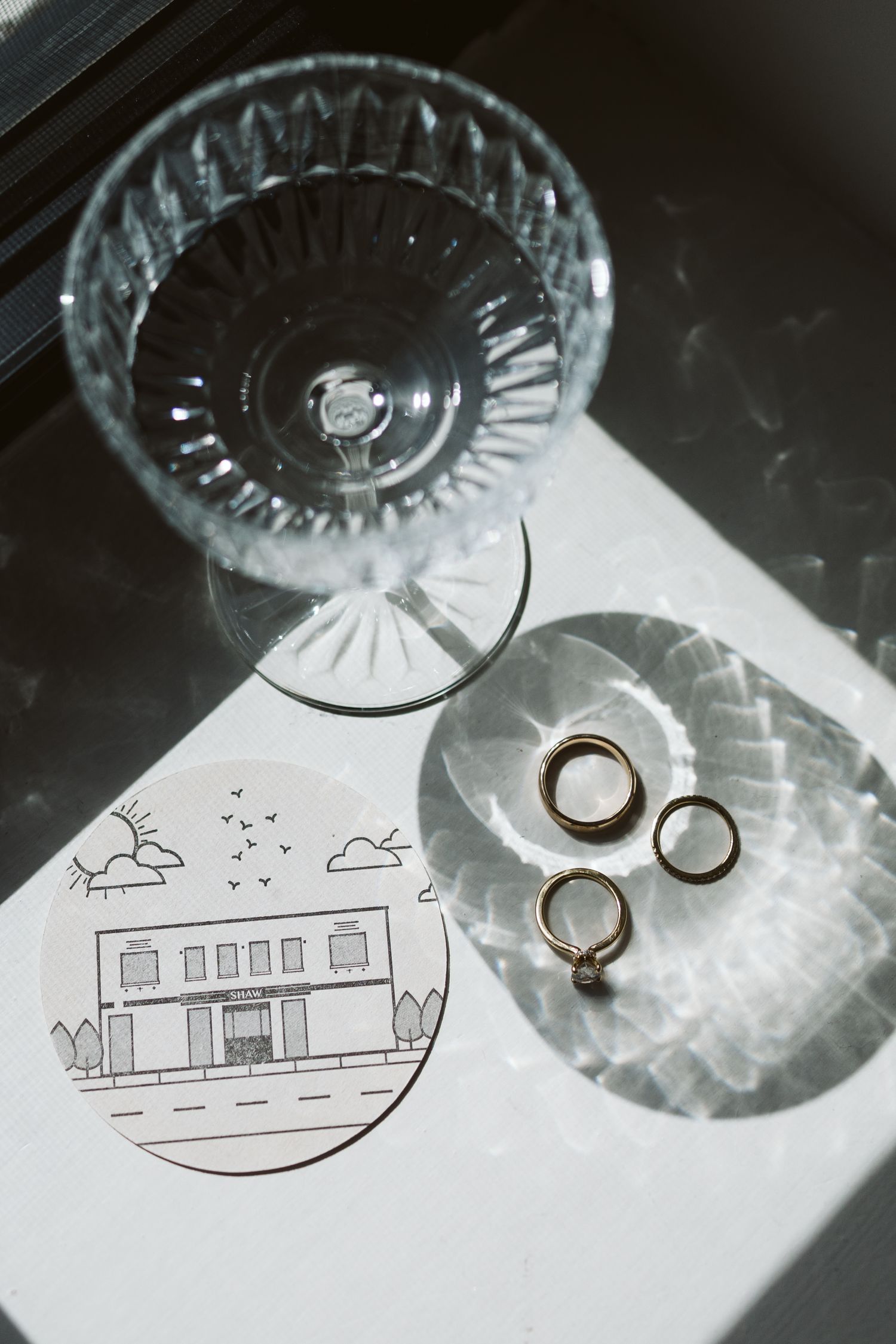 Wedding rings placed on a paper with simple architectural sketches, photographed against a light surface.
