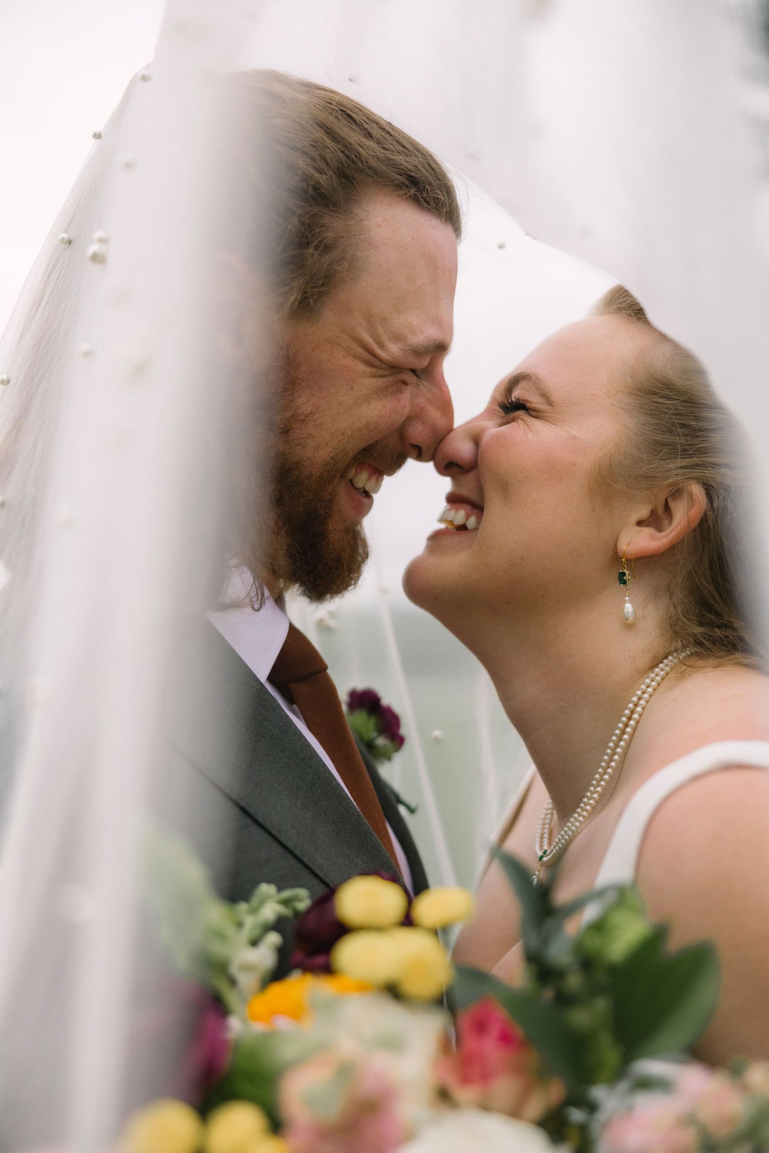 A romantic wedding couple shares intimate moments through a veil in an artistic photo sequence.
