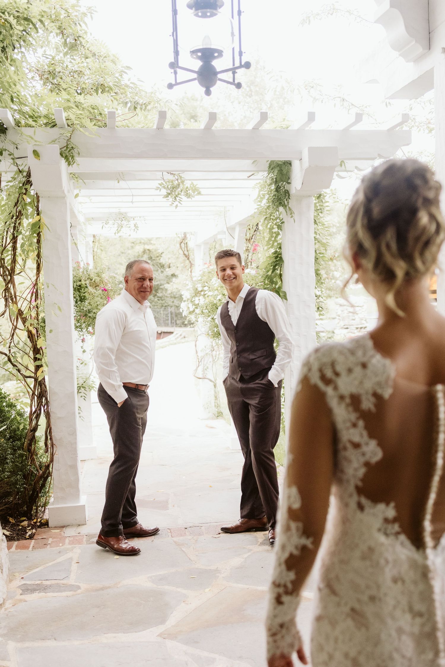 Beautiful white porch with greenery serves as elegant wedding ceremony backdrop.