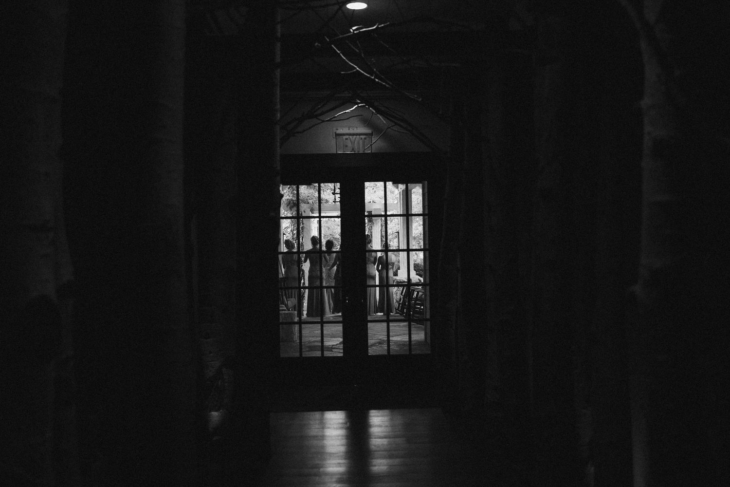 Dark interior hallway with dramatic window lighting creates moody silhouettes.