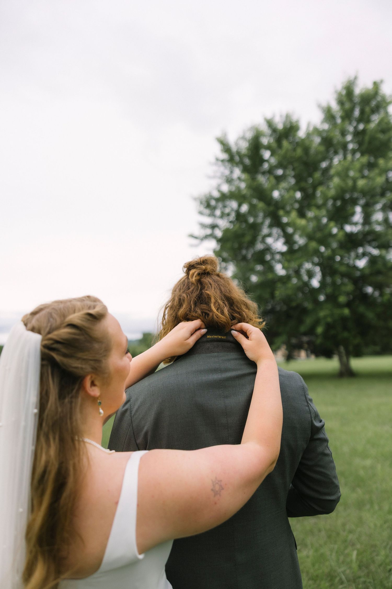 Close-up sequence of a couple in wedding attire embracing in an outdoor setting with trees in the background.