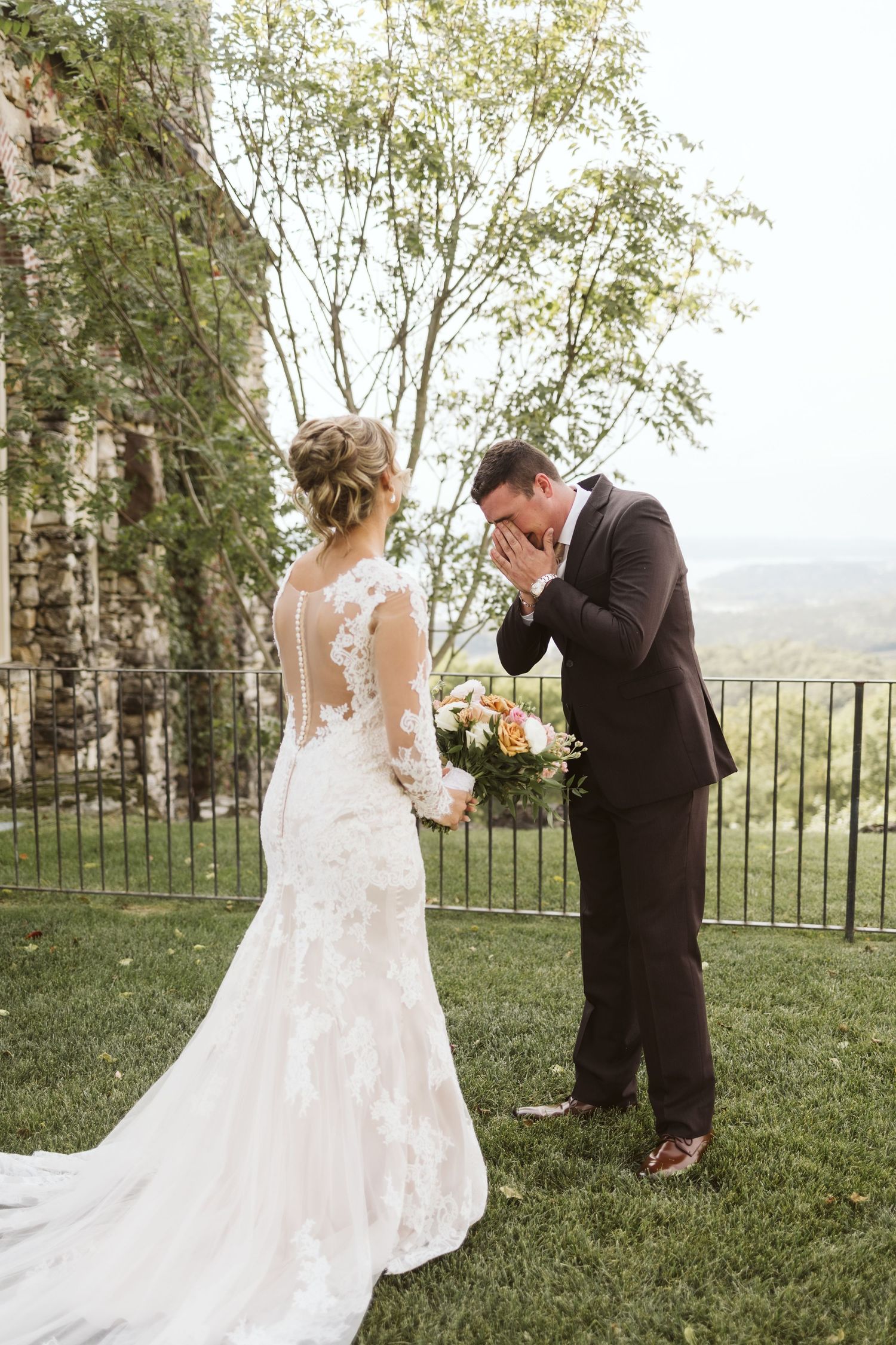 Emotional wedding first look moment captured on scenic clifftop venue.