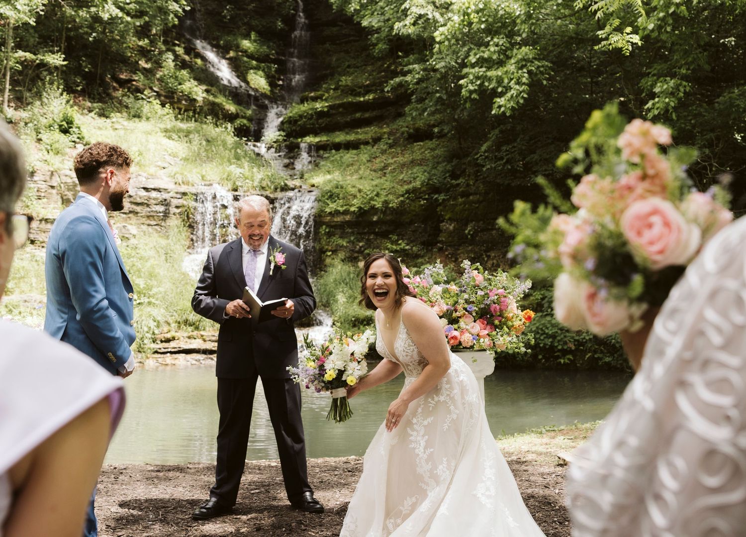 Wedding couple sharing a tender moment outdoors with natural greenery and flowers in the background.