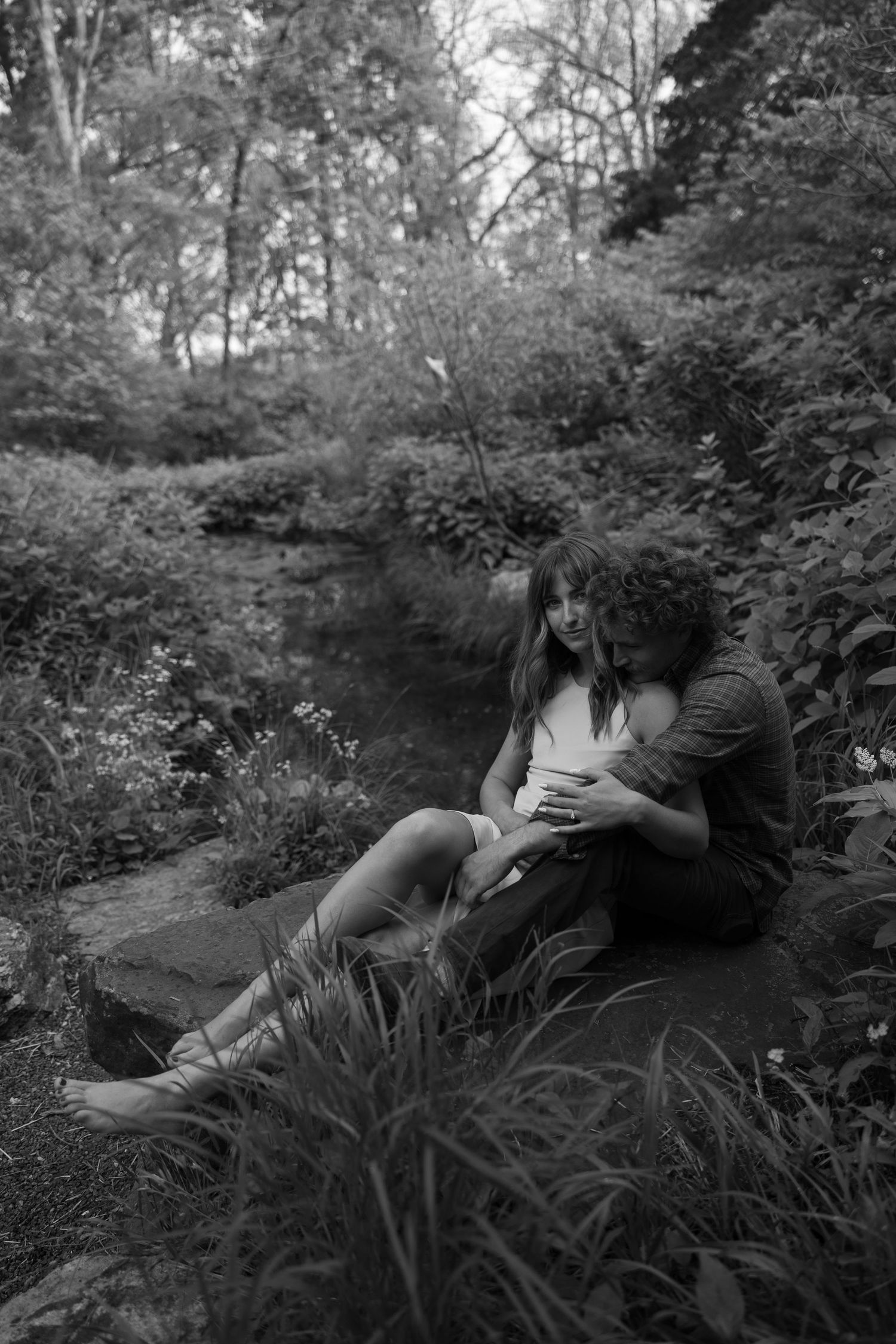Black and white photographs showing tender moments between two people in a garden setting.