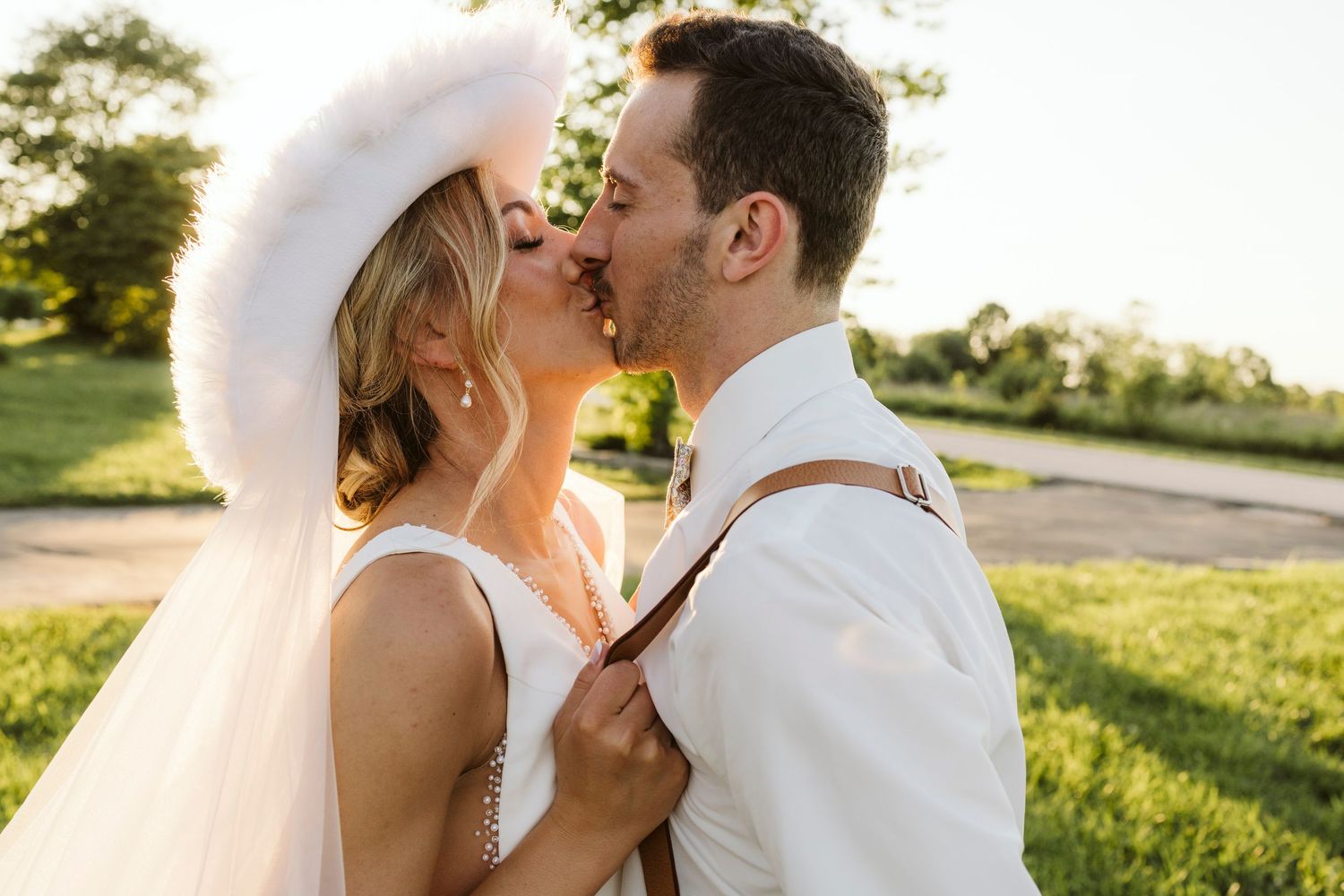 Romantic outdoor wedding portrait at sunset in a natural setting.