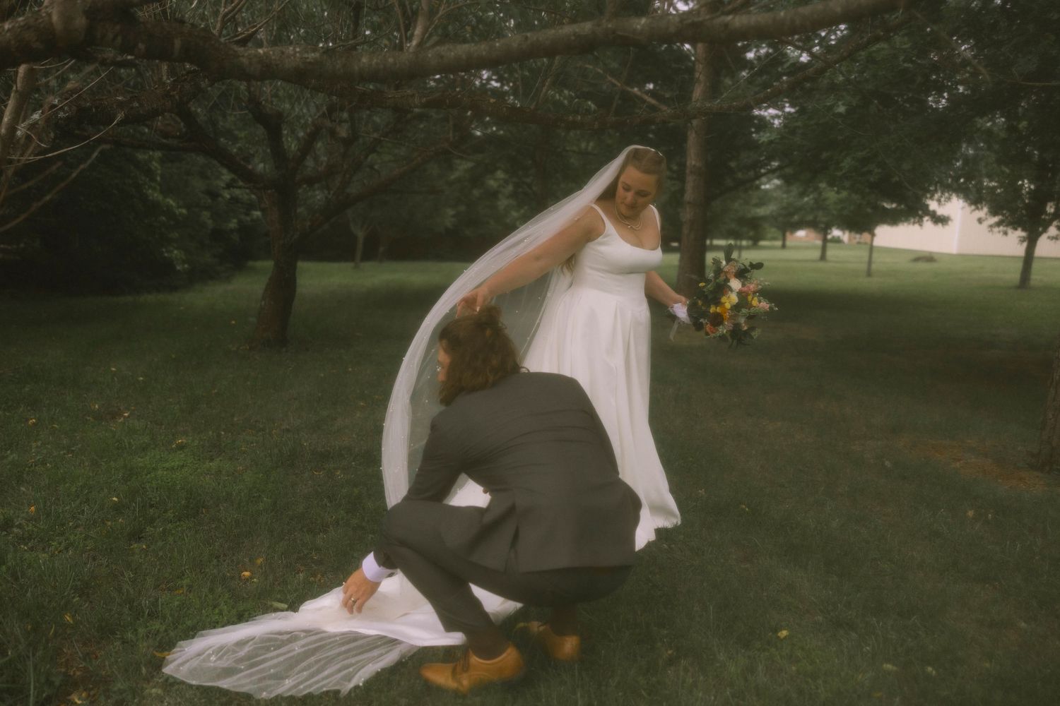 A wedding couple walks through a lush garden path on their special day.