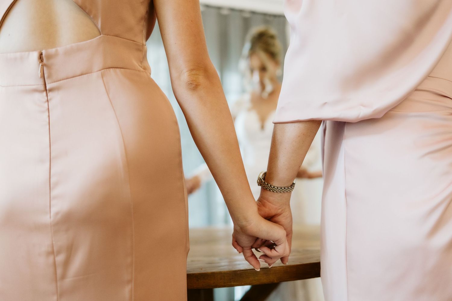 Close-up details of blush pink bridesmaid dresses in natural light.