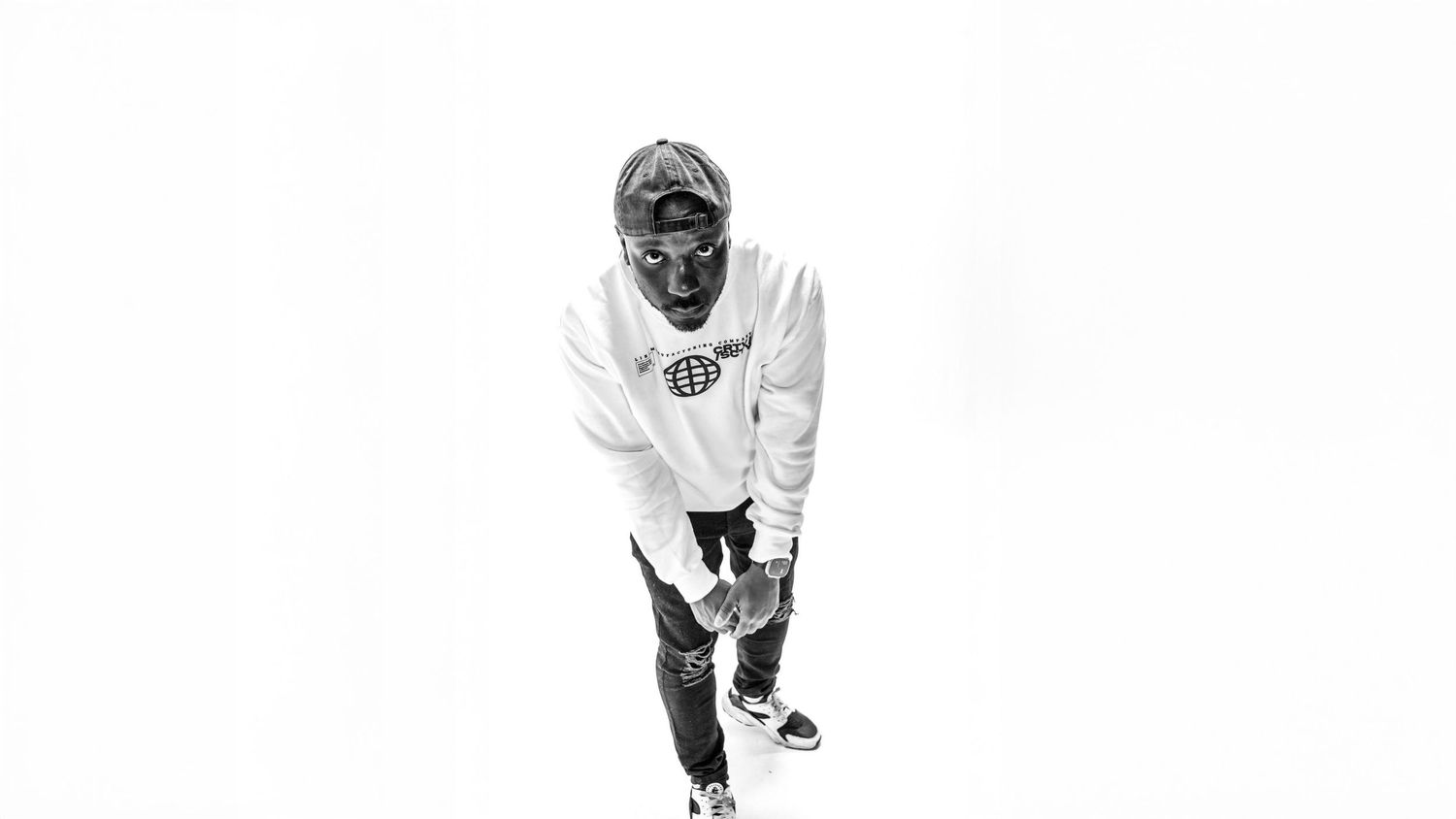 Black and white photo of person in white hoodie bending forward.