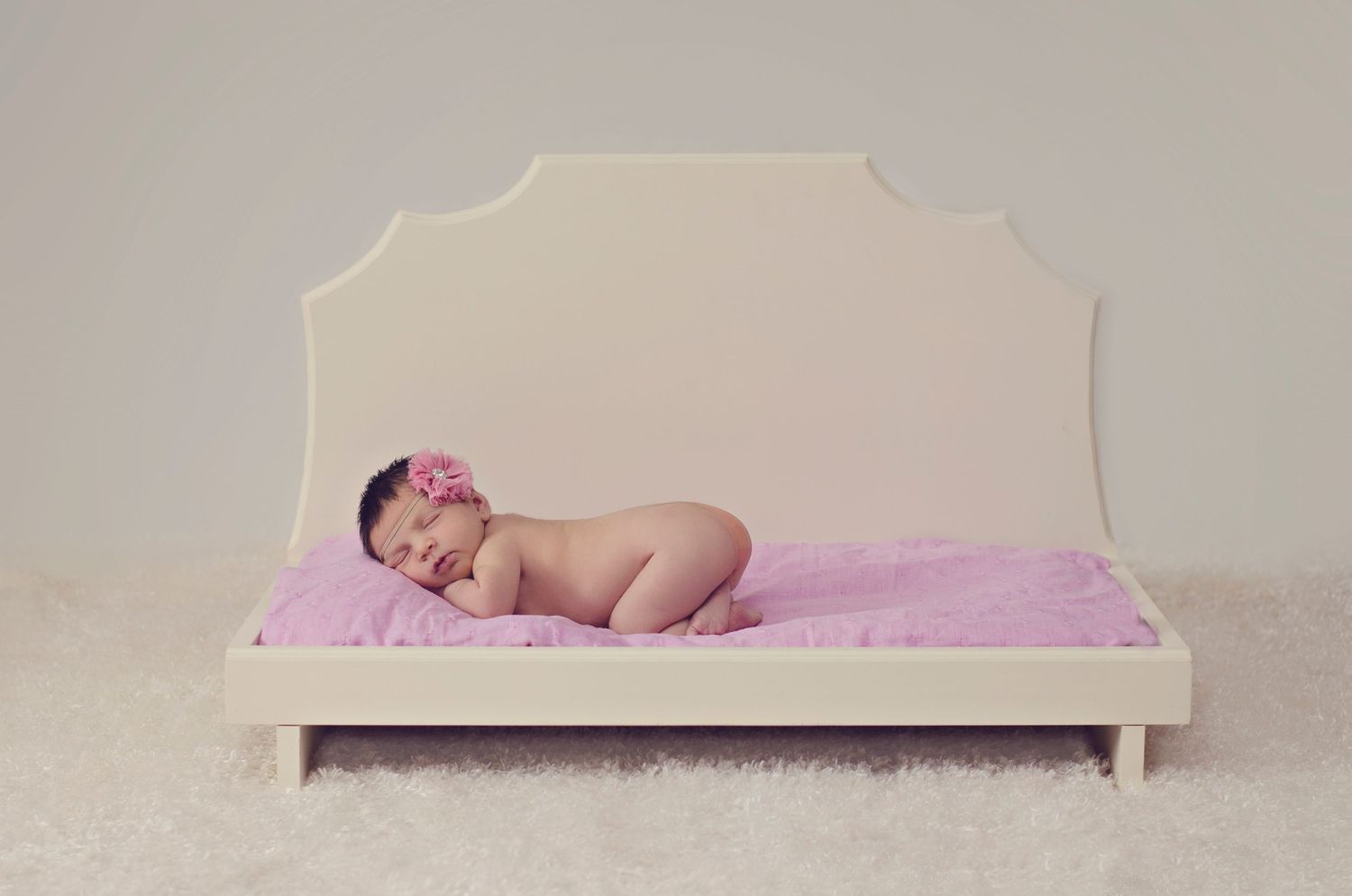 A series of connected images showing a sleeping baby on pink bedding with a white headboard backdrop.