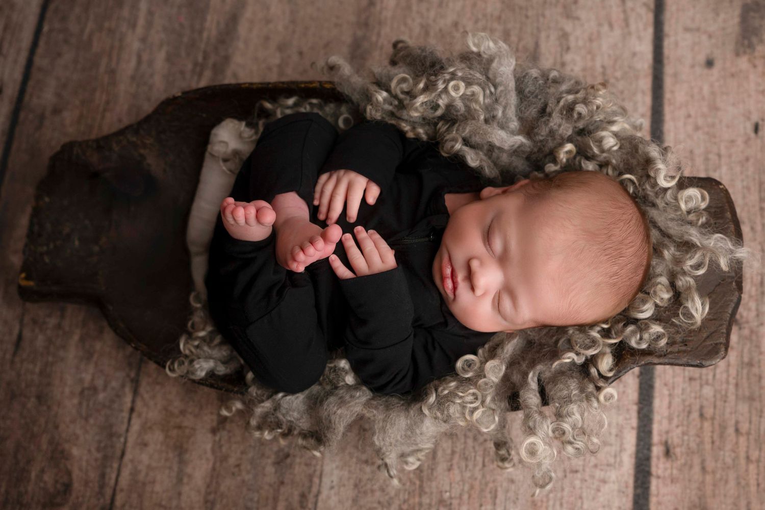 A person with wavy blonde hair lies on a rustic wooden floor in an artistic portrait series of multiple poses.