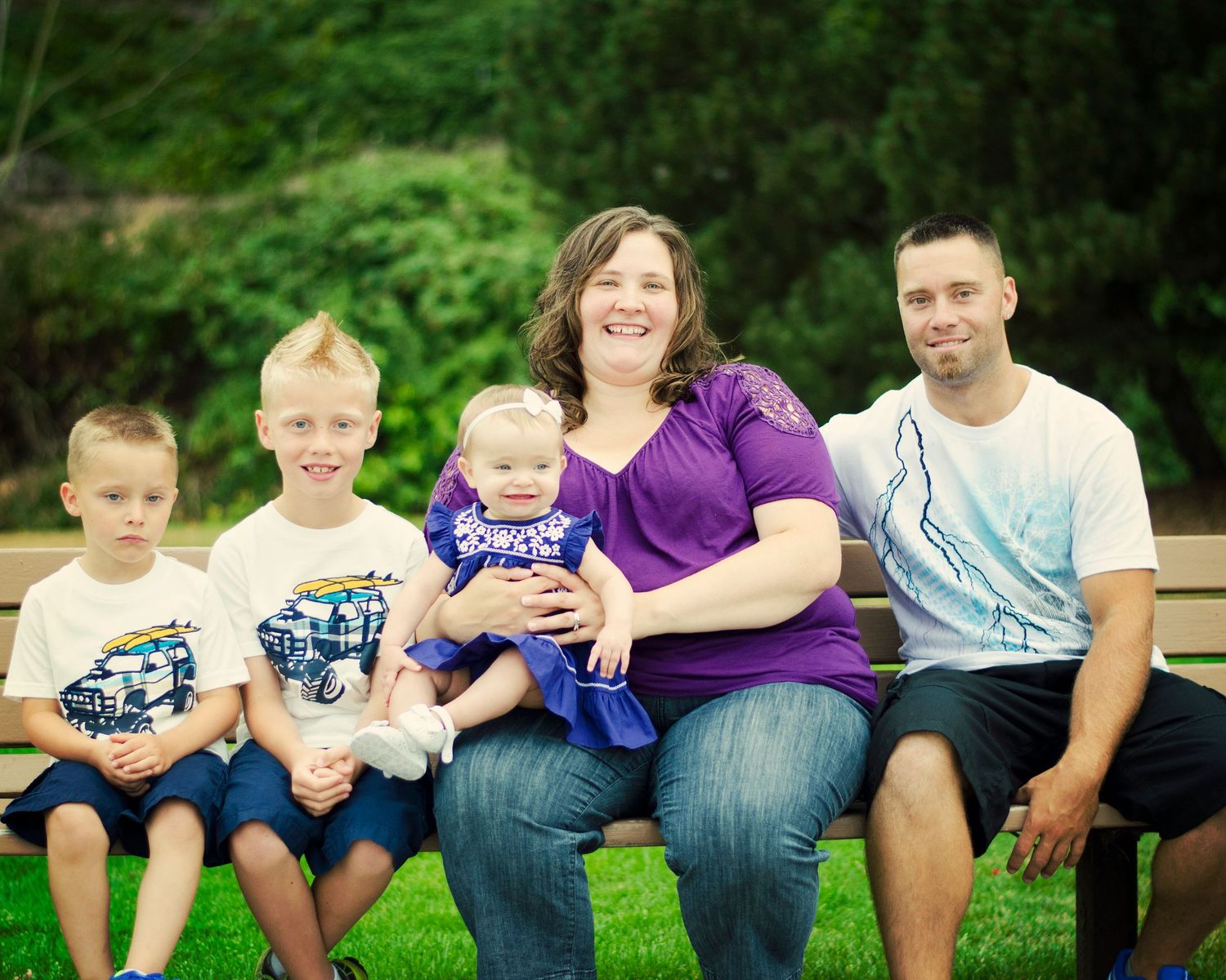 Family members sit together on a grassy hill wearing casual clothing and denim in a series of outdoor portrait photos.