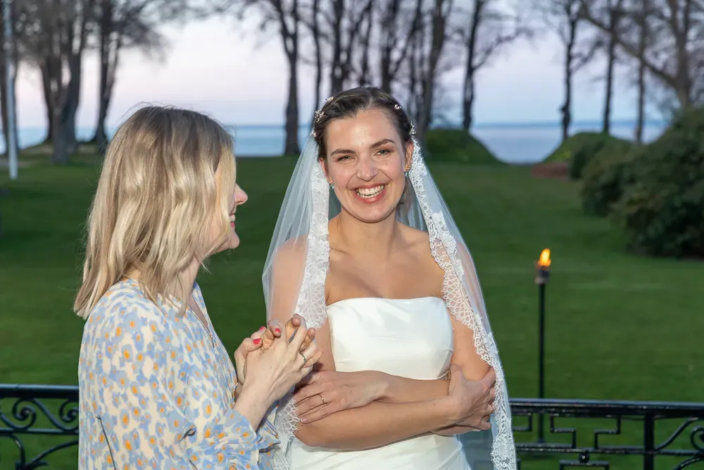 A couple poses for romantic outdoor wedding photos in a garden setting at sunset.