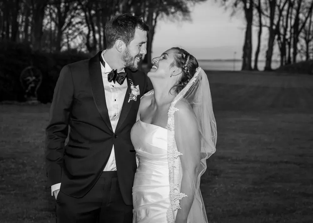 A couple shares an intimate black and white moment during their outdoor wedding celebration.