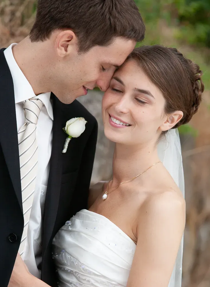 A romantic wedding photoshoot series showing tender moments between the bride and groom with a white rose boutonniere.