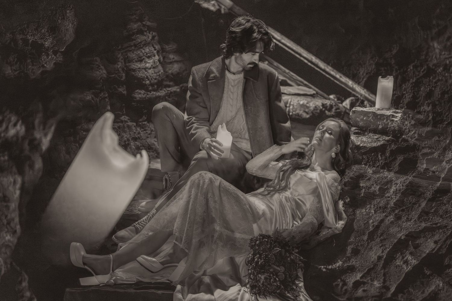 A vintage black and white photo shows several people resting in casual positions on outdoor terrain.