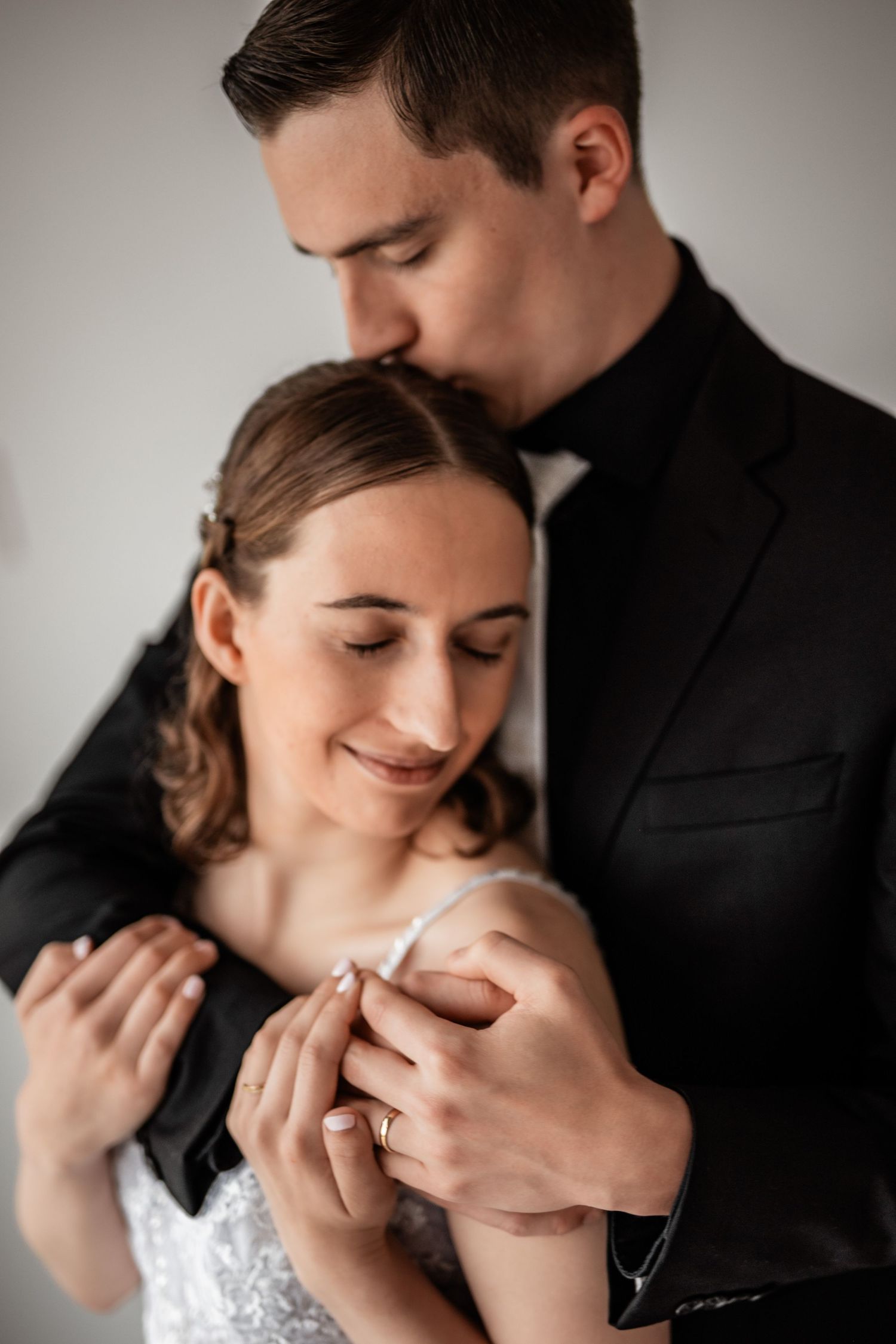 Romantic couple in wedding attire embrace tenderly with soft lighting in a series of intimate photos.