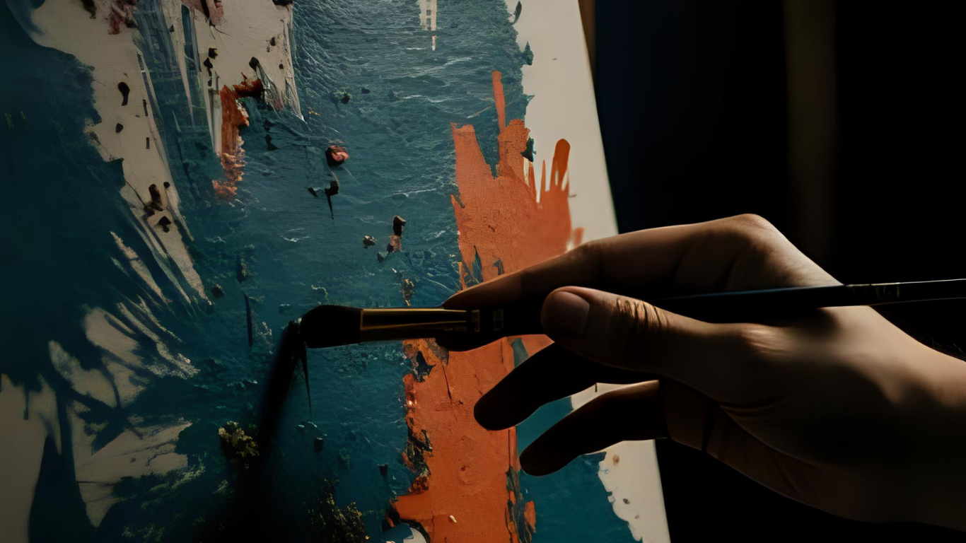 Close-up of hands painting an abstract artwork with bold blue and orange colors.