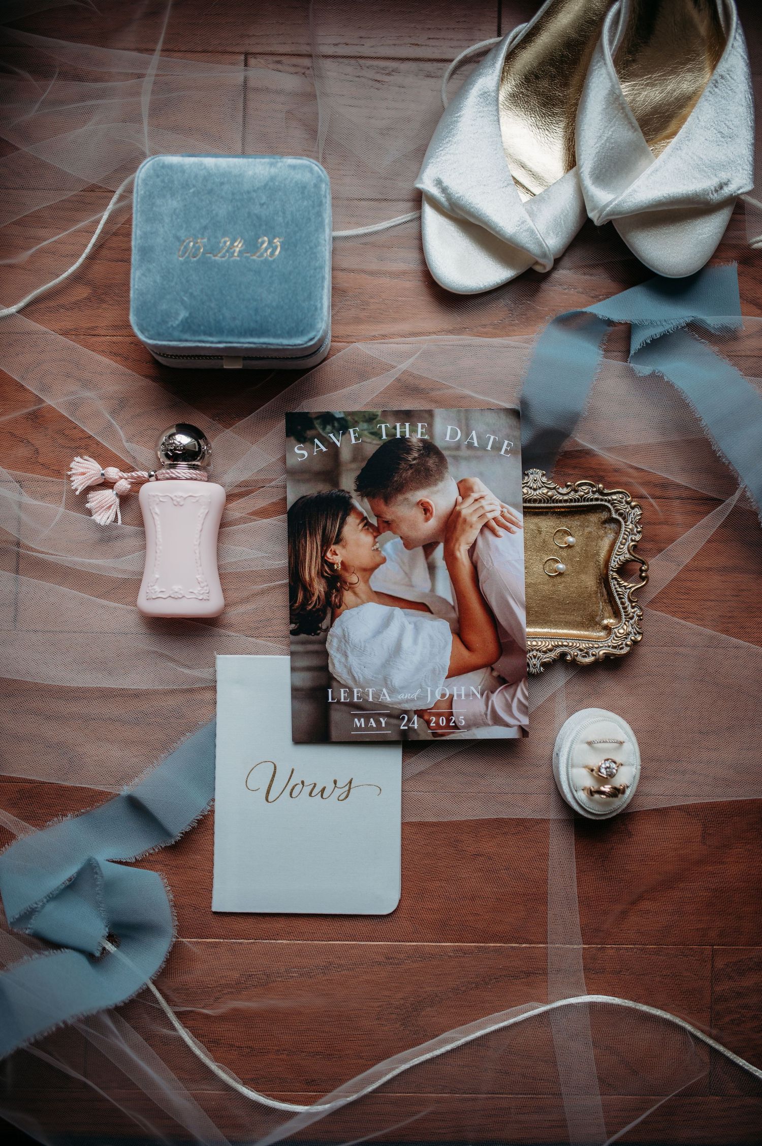 Catholic wedding details flat lay of the save-the-date, and white shoes, vows book, perfume bottle, blue velvet ring box and silk ribbons.