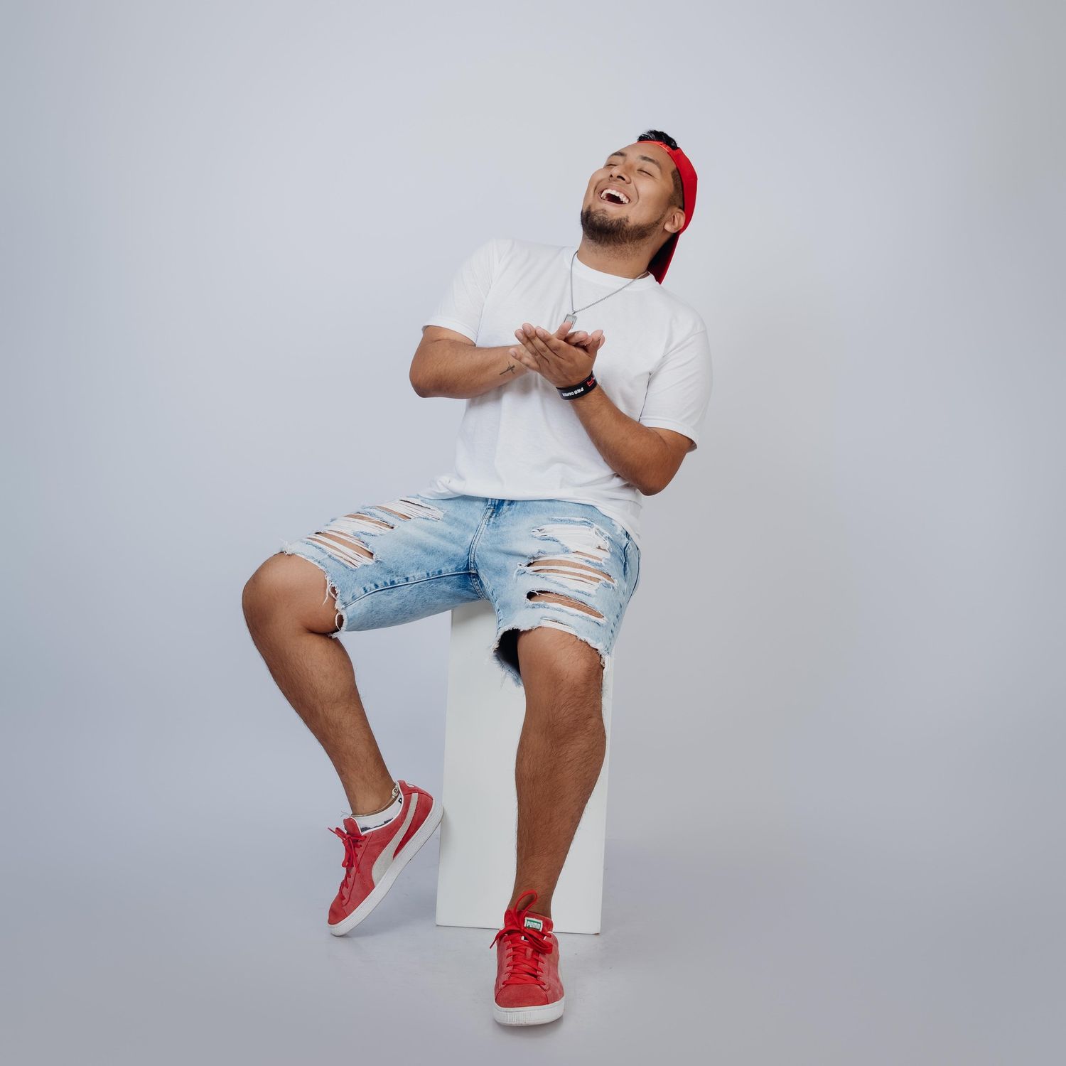 Sequence of dynamic dance poses showing white shirt and red sneakers against a light gray studio background.