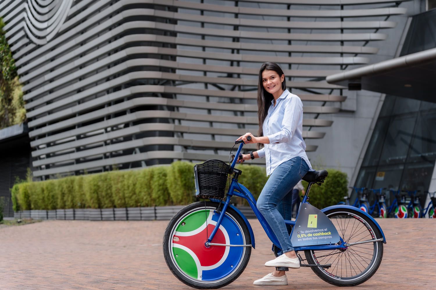 Mujer profesional en bicicleta frente a Parque La Colina, Bogotá, fotografía empresarial outdoor