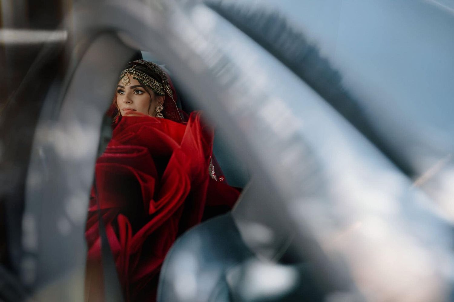 Novia con vestido y tocado tradicional mirando a través de la ventana de un automóvil