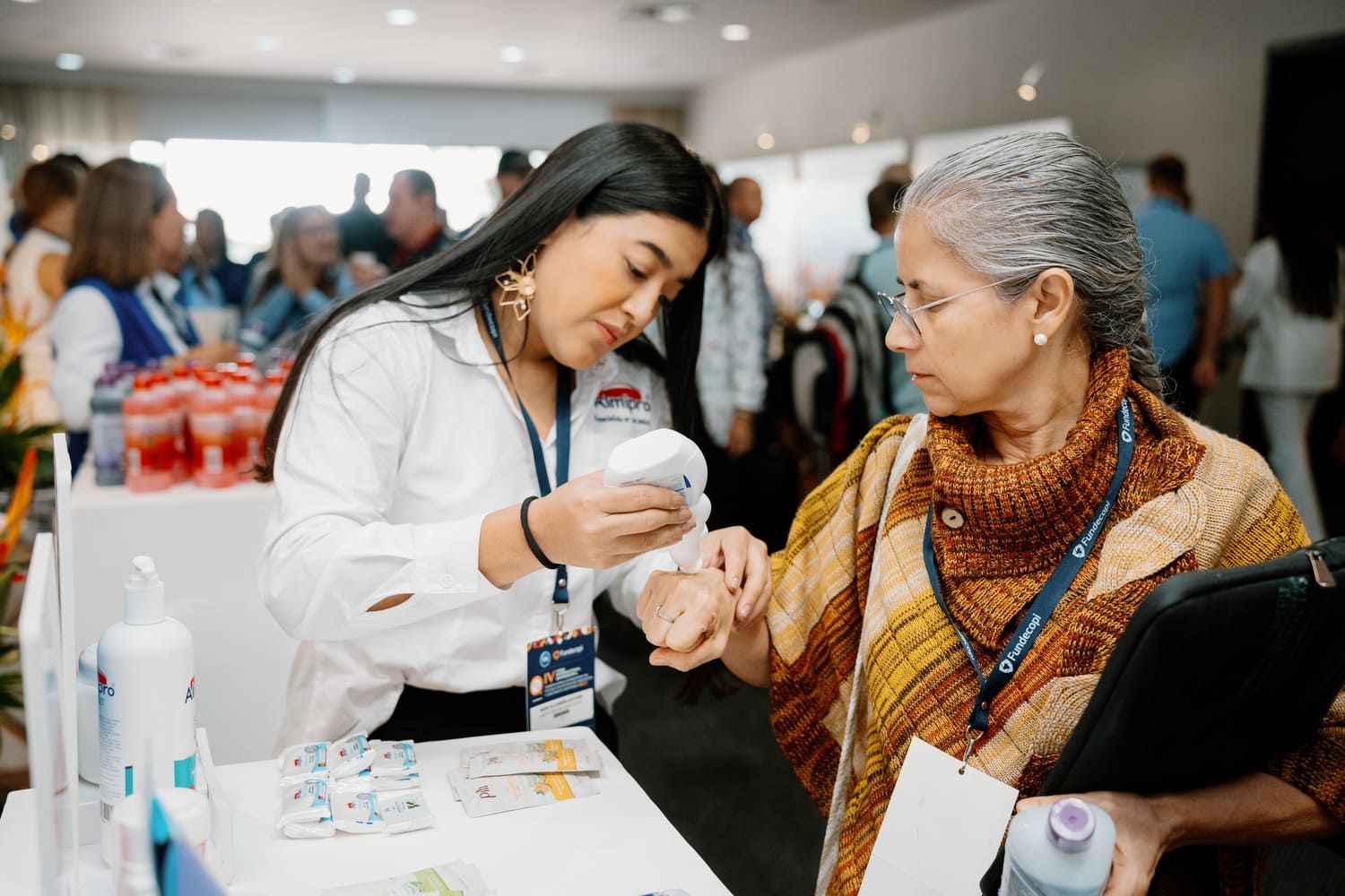 Demostración de producto a asistente durante feria de salud y networking, fotografía corporativa en Colombia