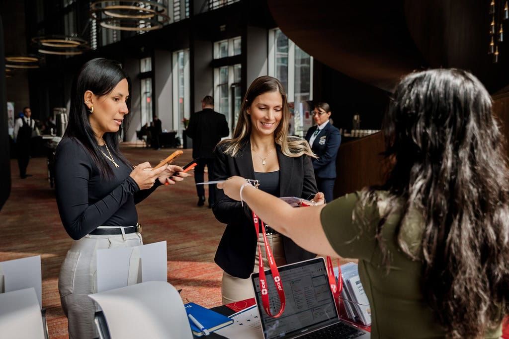 Business colleagues exchange documents and handouts during a professional meeting in an office setting.
