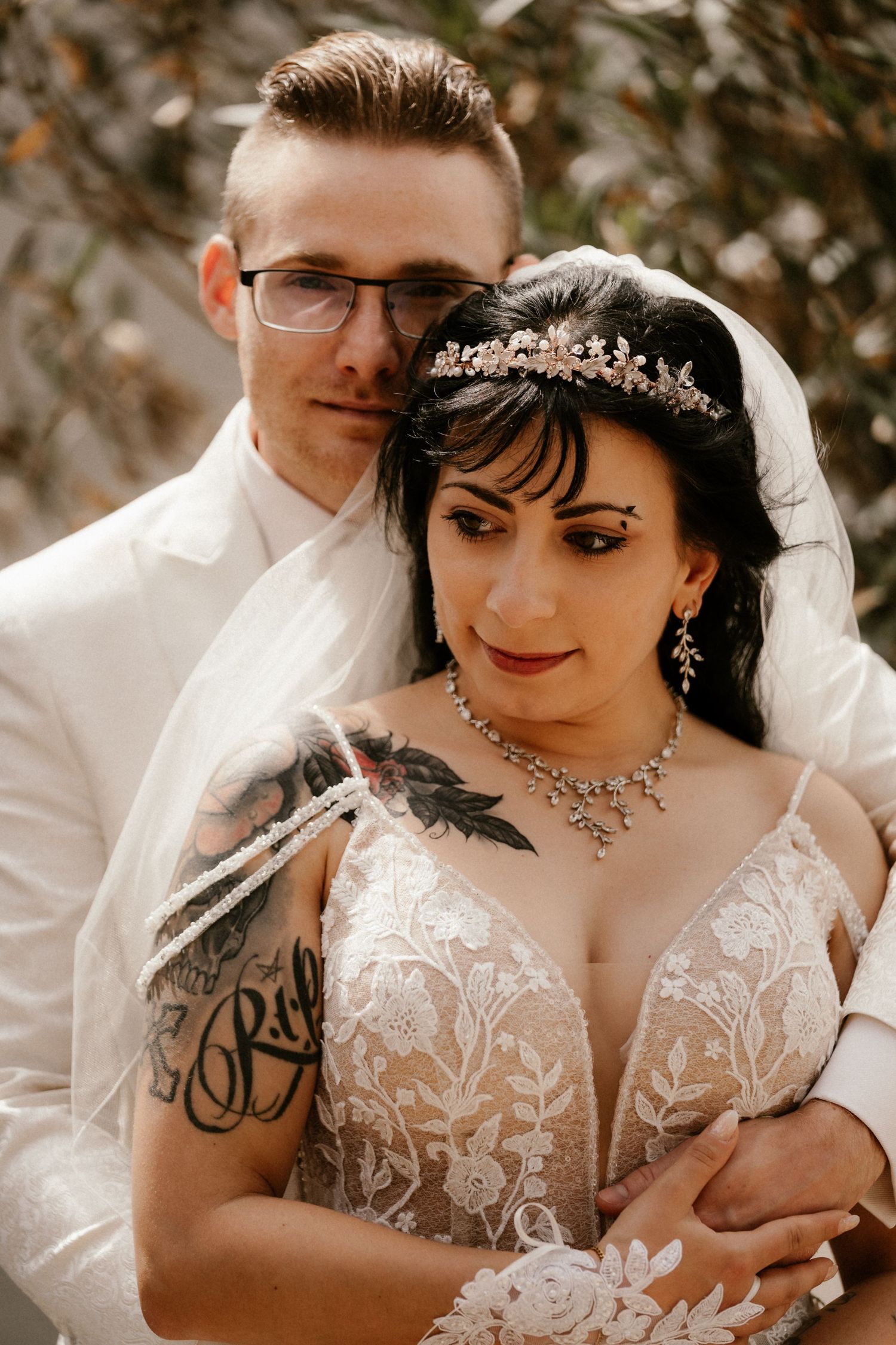 Close-up wedding photo featuring the newlyweds in a romantic pose with ornate bridal jewelry and white attire.