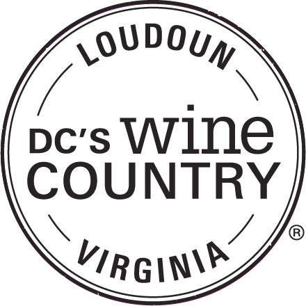 A circular black logo for DC's Wine Country in Loudoun, Virginia with text arranged around a circular border design.