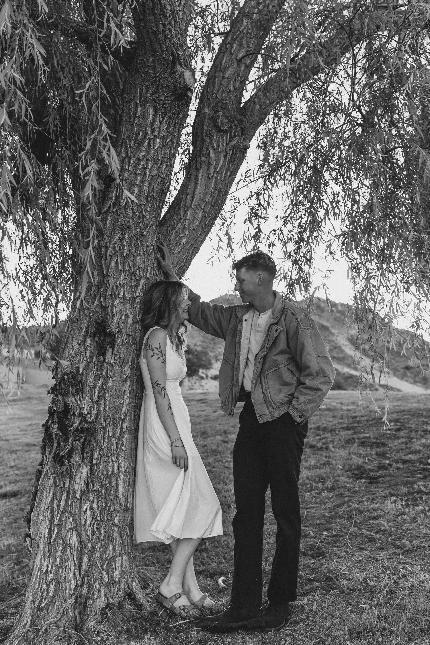 A vintage black and white photograph of a romantic couple standing beneath a willow tree in North Carolina.
