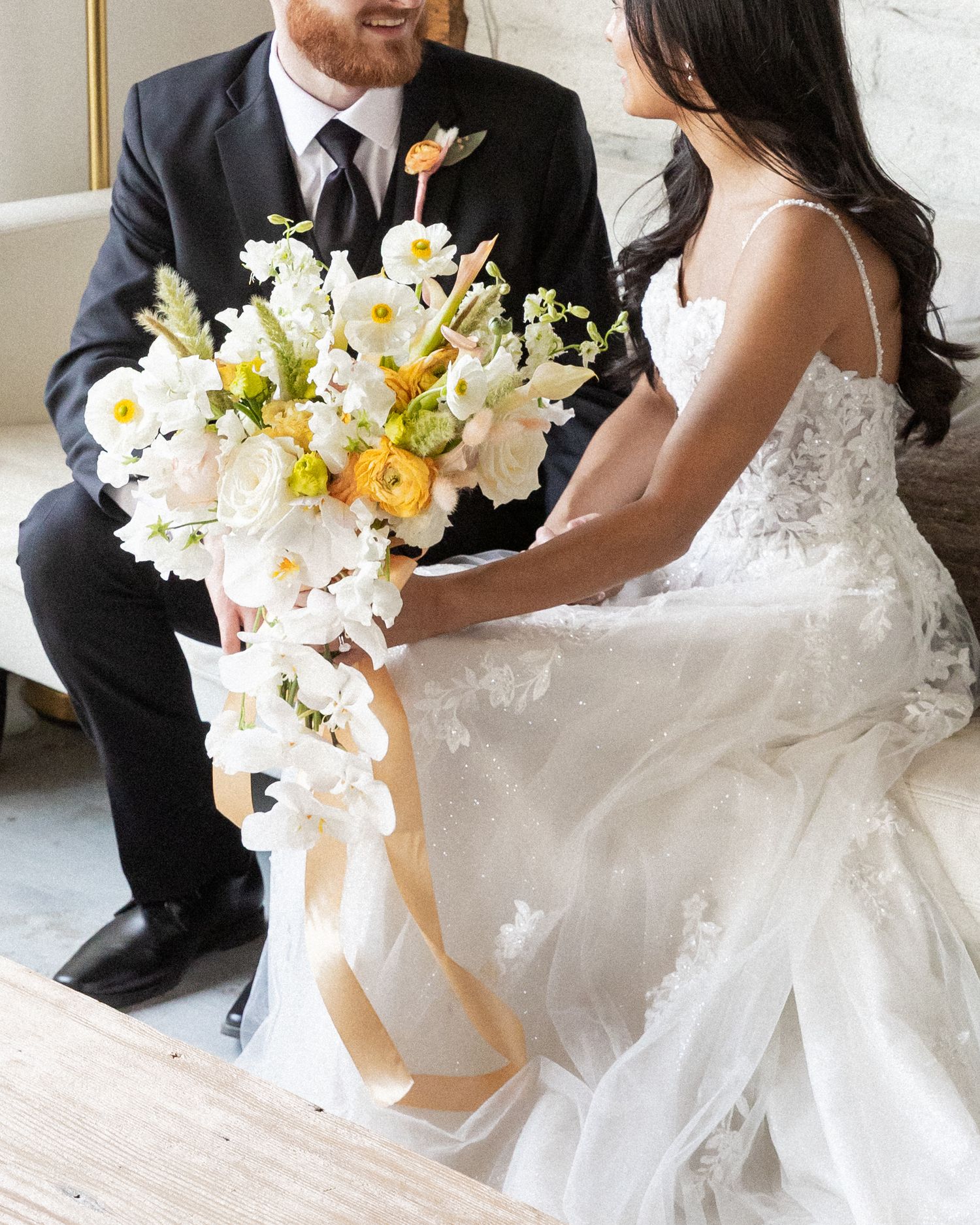 A bride and groom share intimate wedding day moments, with elegant white and peach floral bouquets and formal attire. north carolina wedding