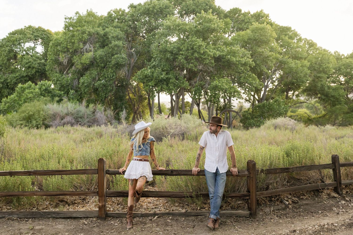 Romantic couples photoshoot in a rustic outdoor setting with wooden fences and green foliage in North Carolina.
