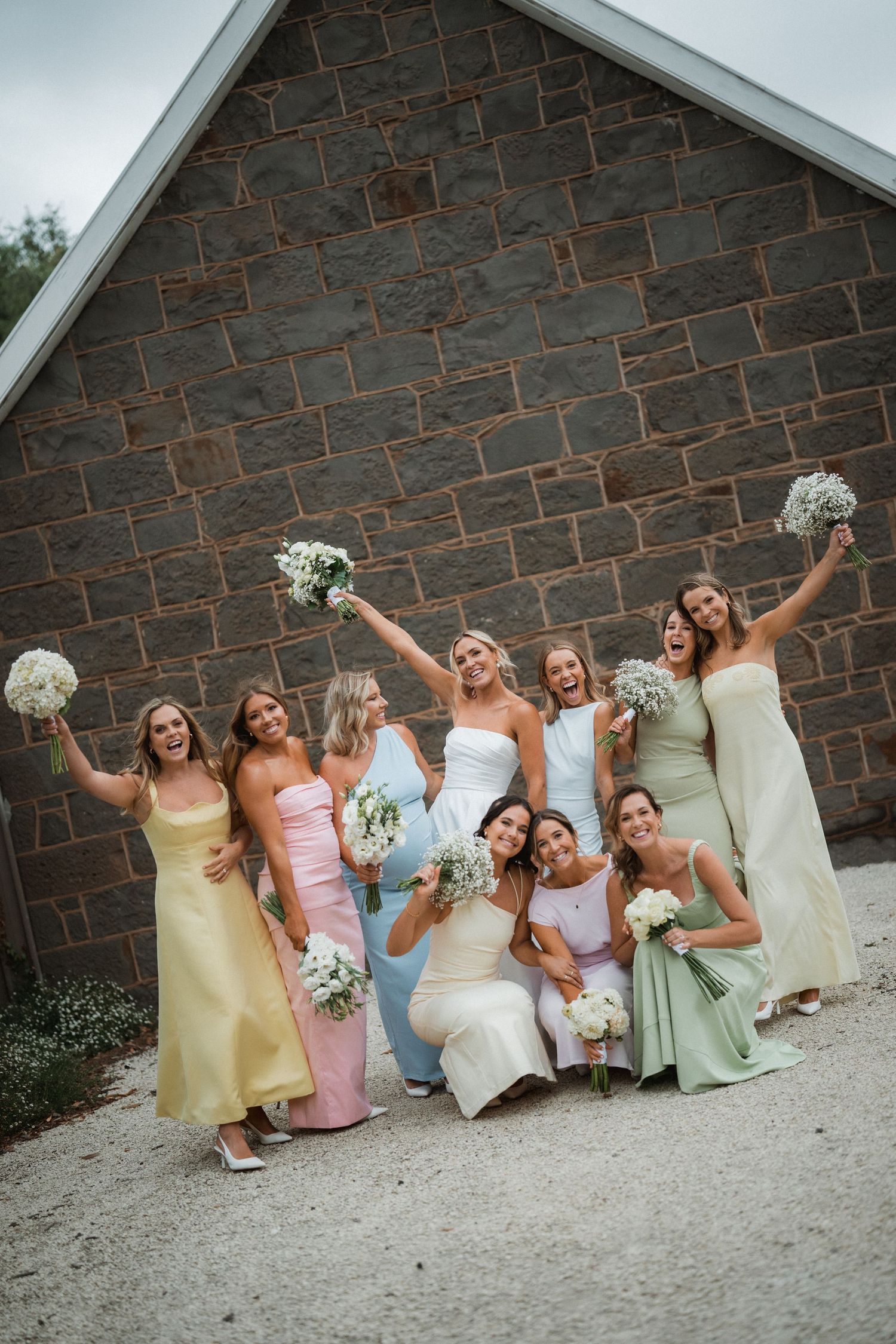 A group celebration photo against a stone wall backdrop.
