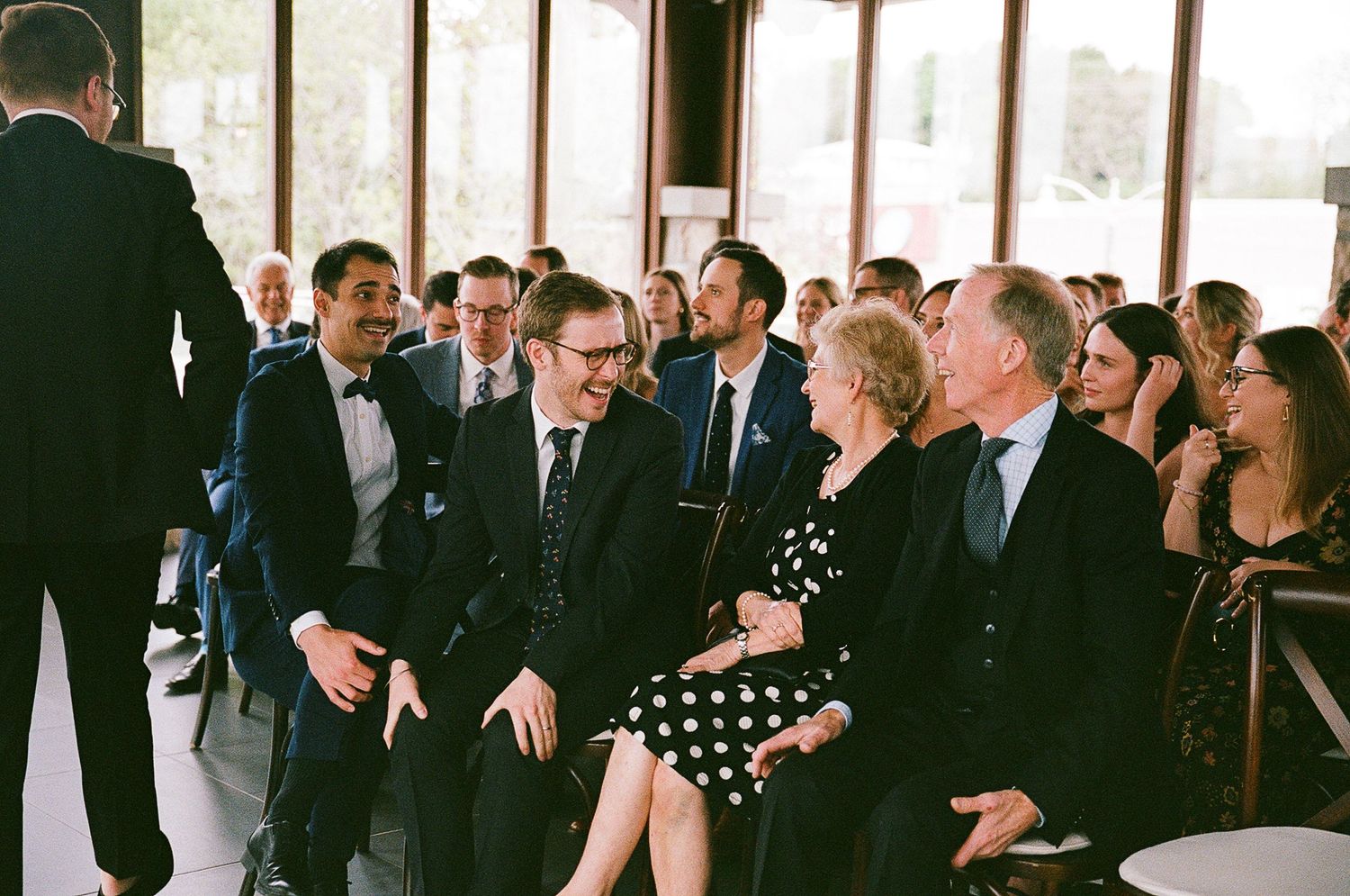 Guests in formal attire seated at a social gathering or event.