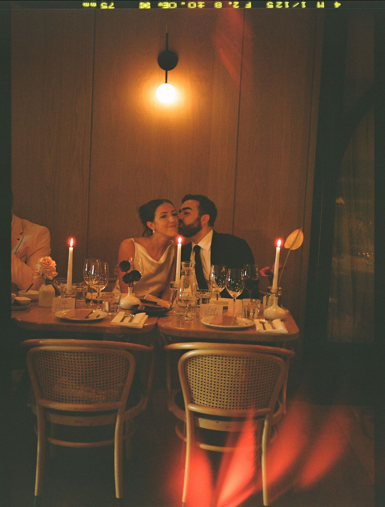 A romantic candlelit dinner scene at a dimly lit table with wine glasses and an intimate atmosphere.