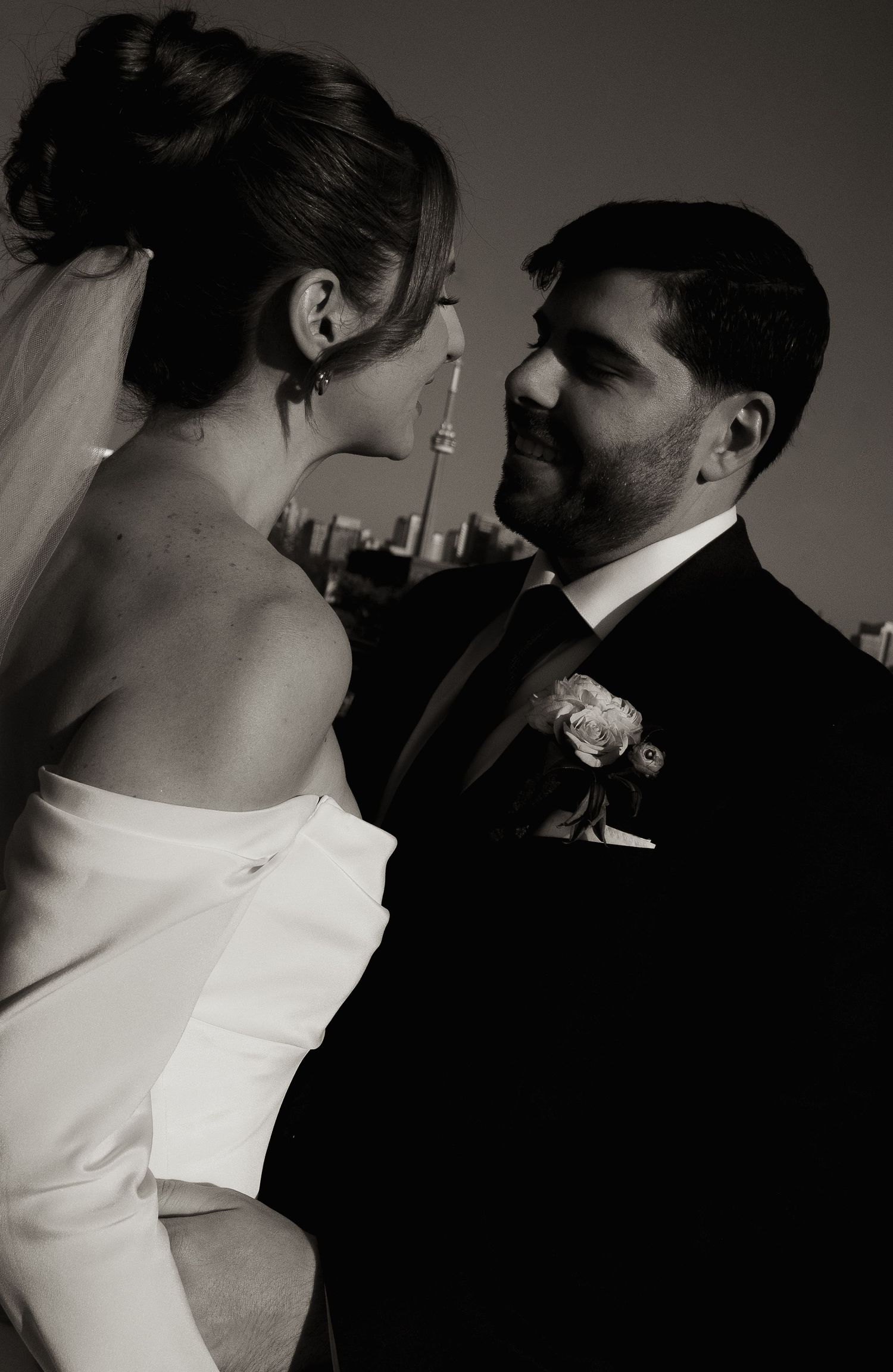 Black and white portrait of a bride and groom gazing at each other on their wedding day.