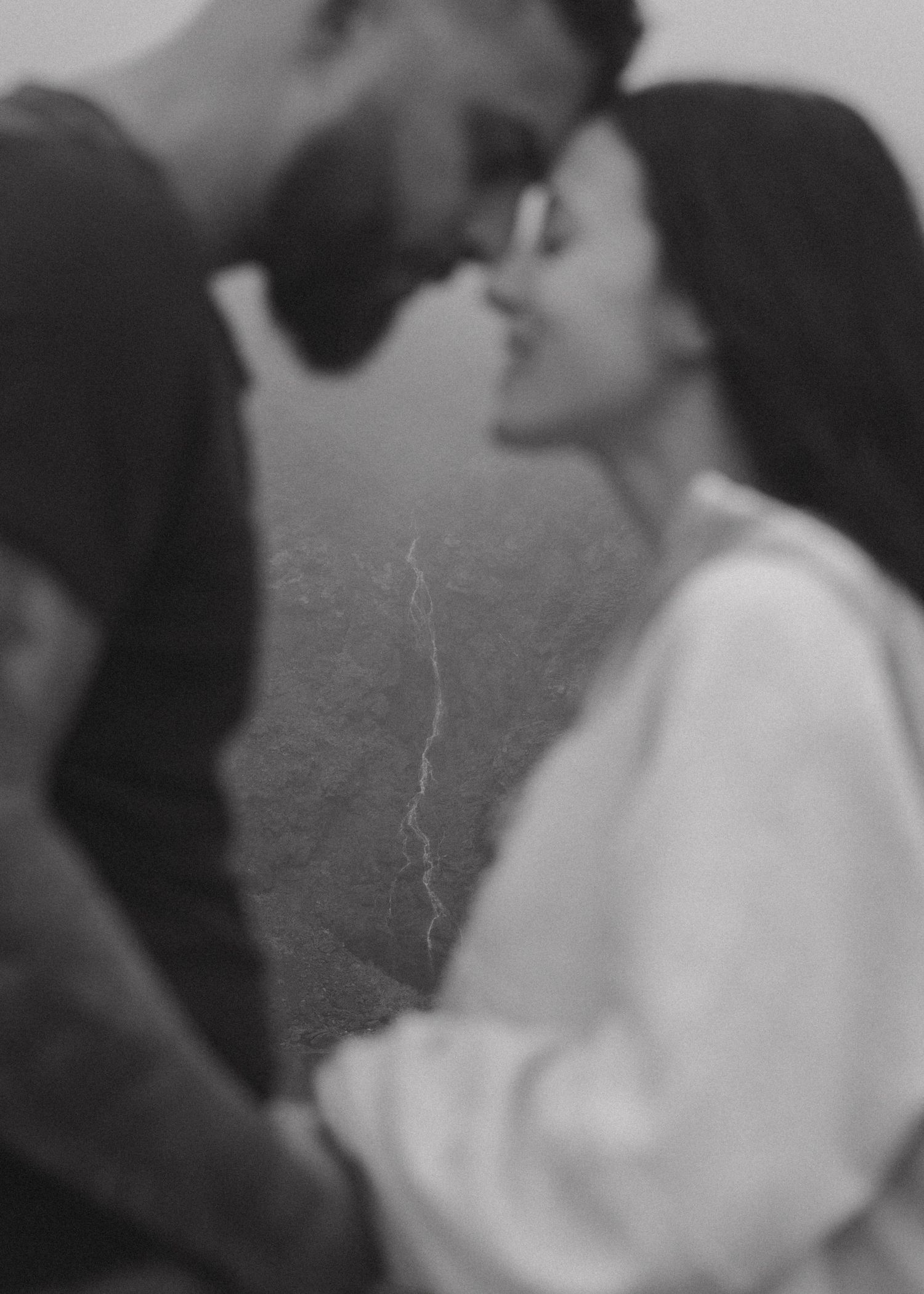 A black and white film strip sequence showing two figures in profile leaning toward each other in an intimate moment.