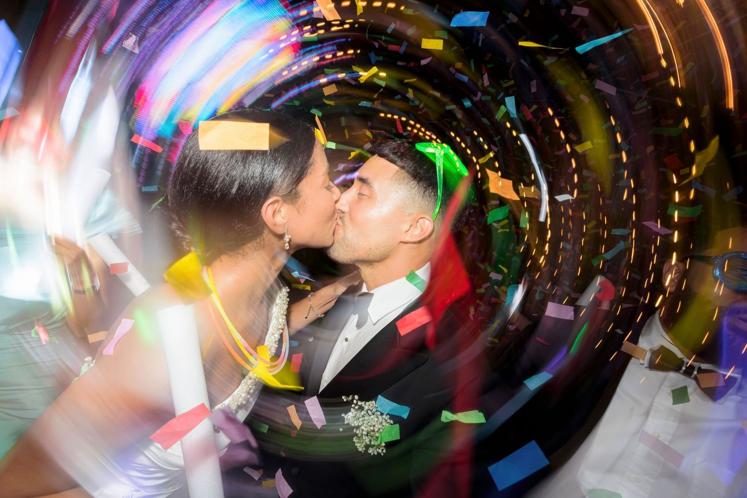 Creative spinning camera effect capturing a romantic moment with colorful lights at a wedding reception.