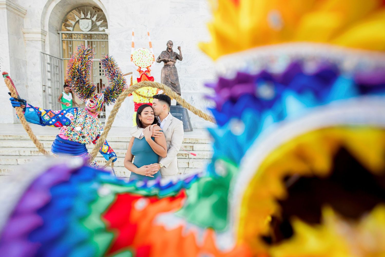 Creative wedding photo through colorful fabric showing couple in bright celebration.