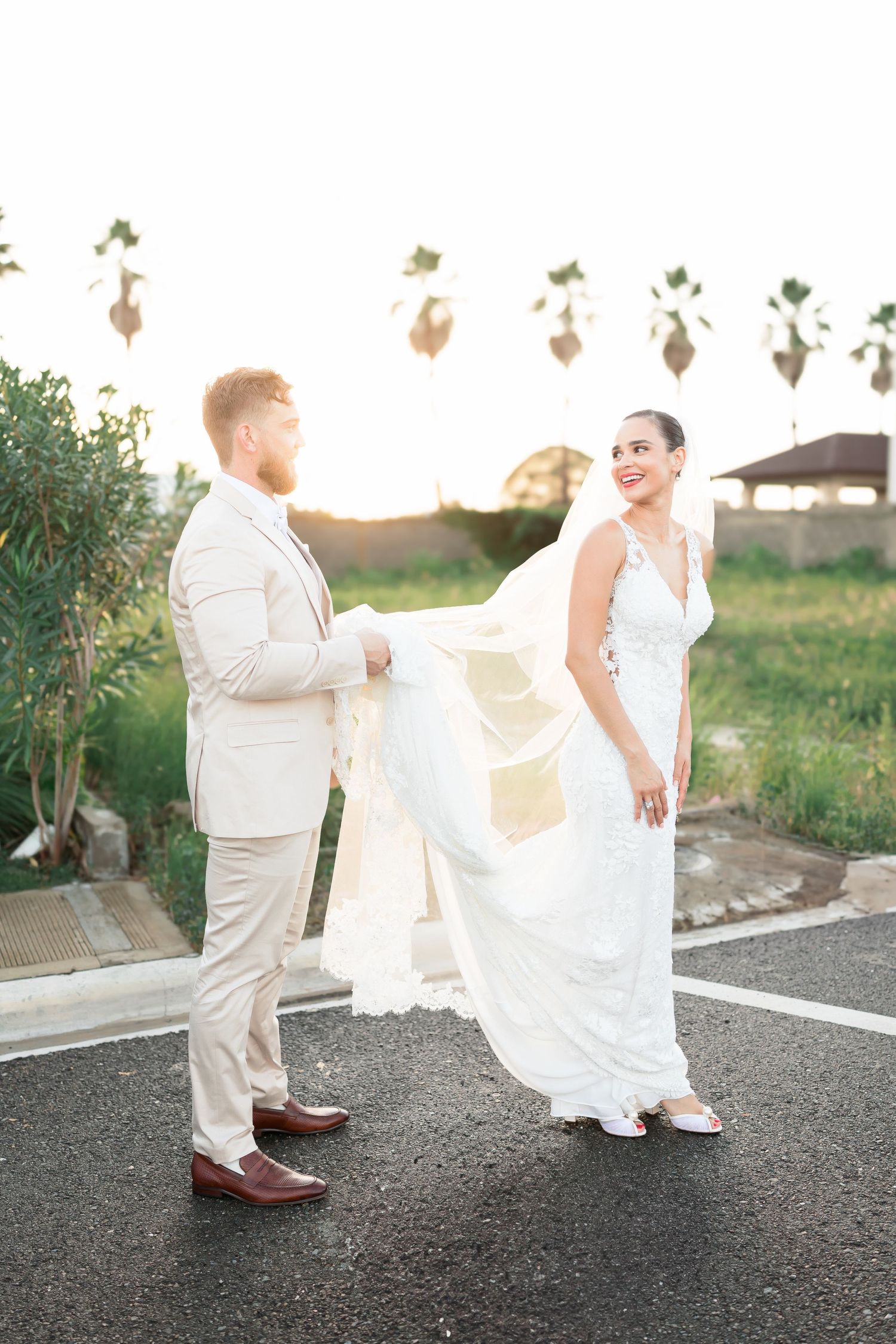 A sunset wedding photoshoot featuring a couple in elegant white attire against a natural outdoor backdrop.