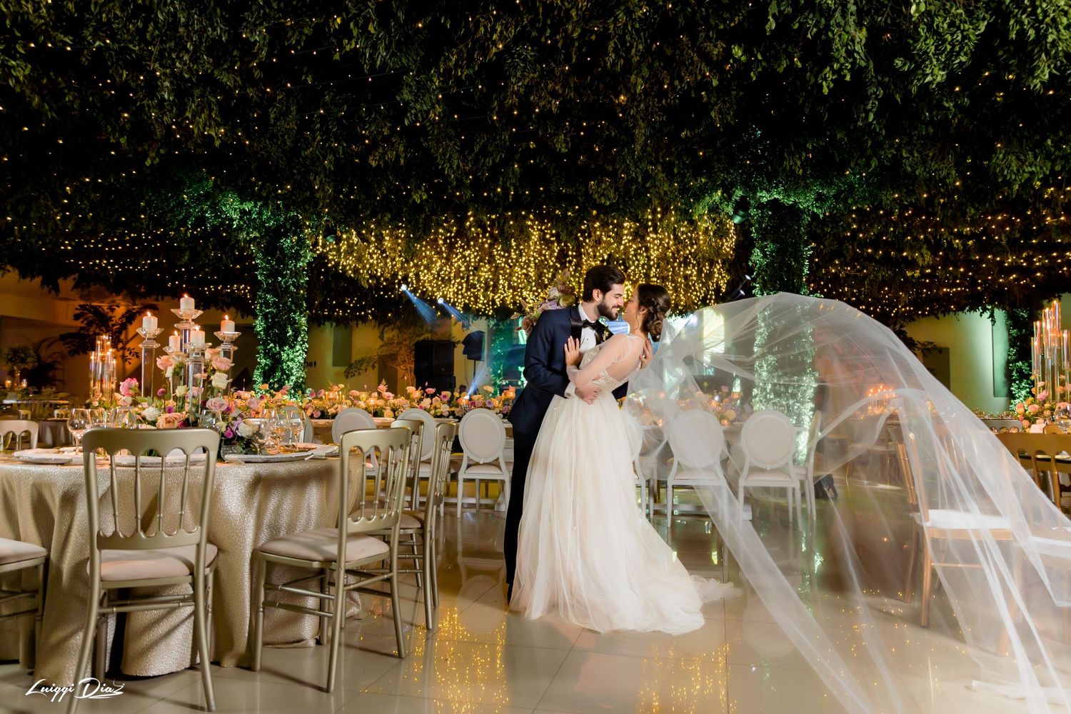 An elegant wedding reception with string lights, floral decor, and beautifully set tables in a garden setting.