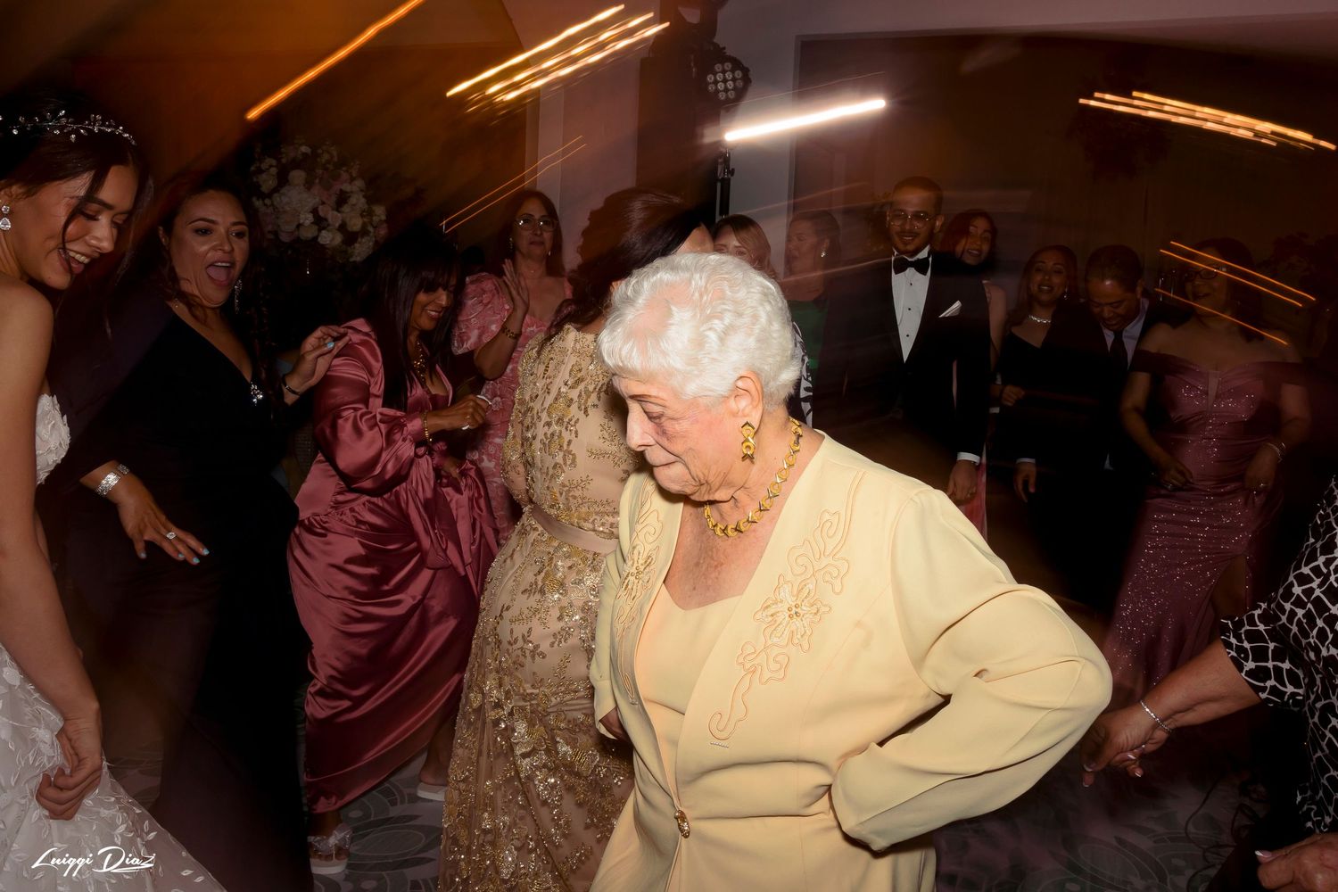 Lively wedding reception dance floor with guests enjoying the celebration in formal attire.