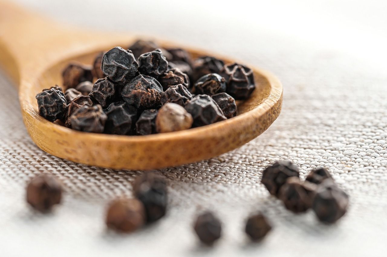 Photo de grains de poivre dans une cuillère en bois : épices.