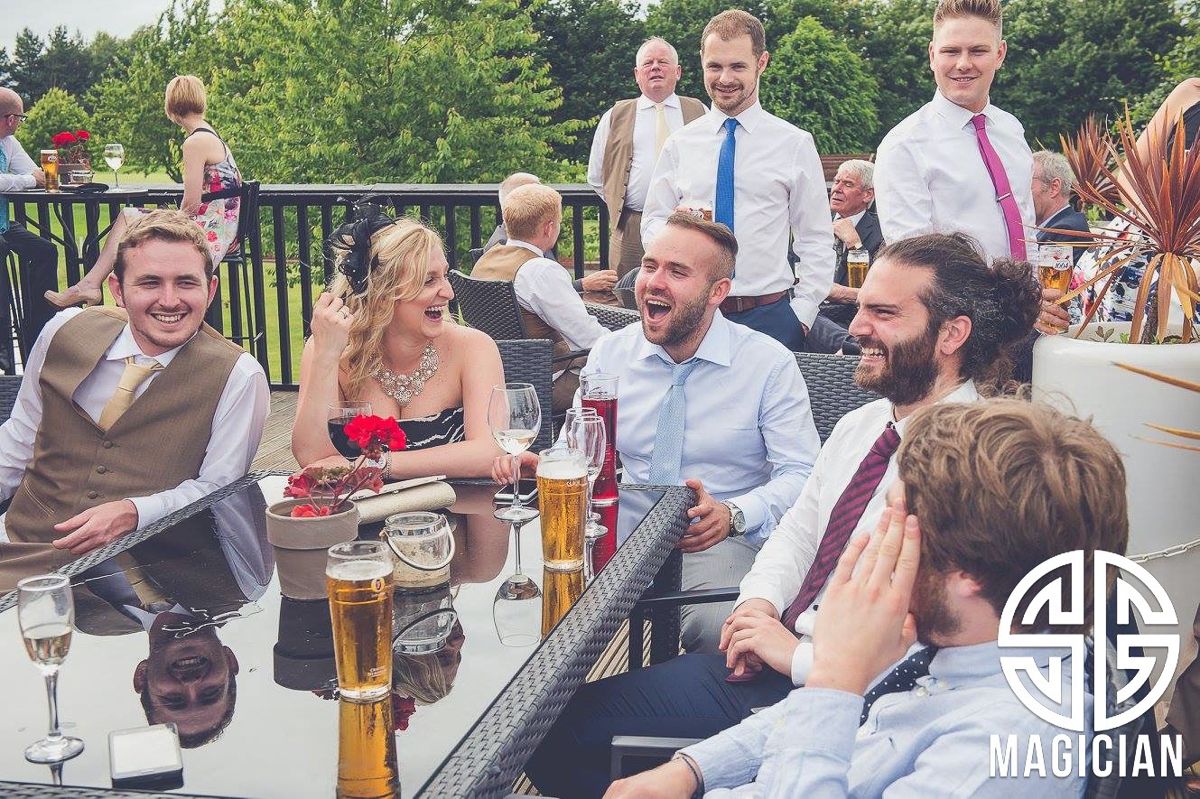 Wedding guests enjoying drinks and conversation at outdoor reception venue.