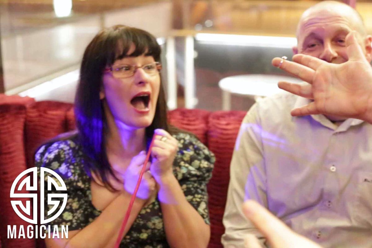 Spectators showing dramatic reactions during a magic show performance.